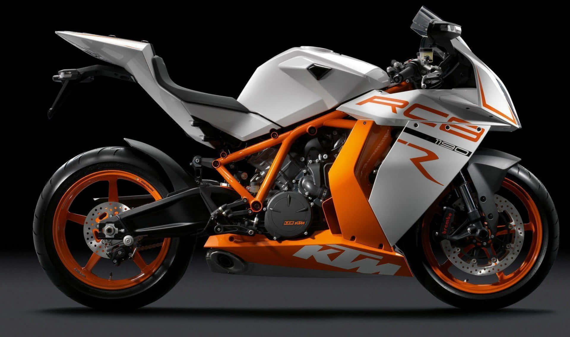 KTM 1190 RC8圖片 壁紙 — 一輛帶有橙色和白色點綴的時尚KTM RC8 R電單車，在黑色背景的戲劇性工作室燈光下展示。