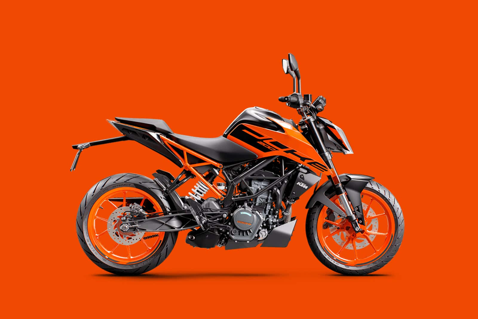 KTM Duke 200摩托車配橙色背景 壁紙 — 一架時尚的黑色和橙色KTM電單車在純色鮮豔橙色背景上側面展示。