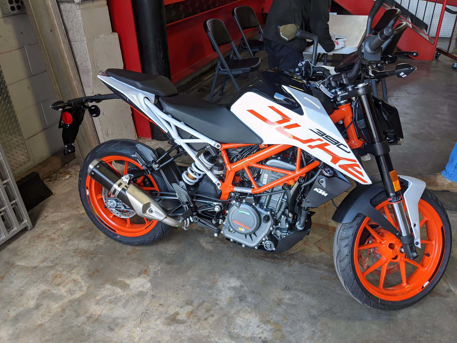 橙色和白色KTM Duke 390電單車停放在車庫中。