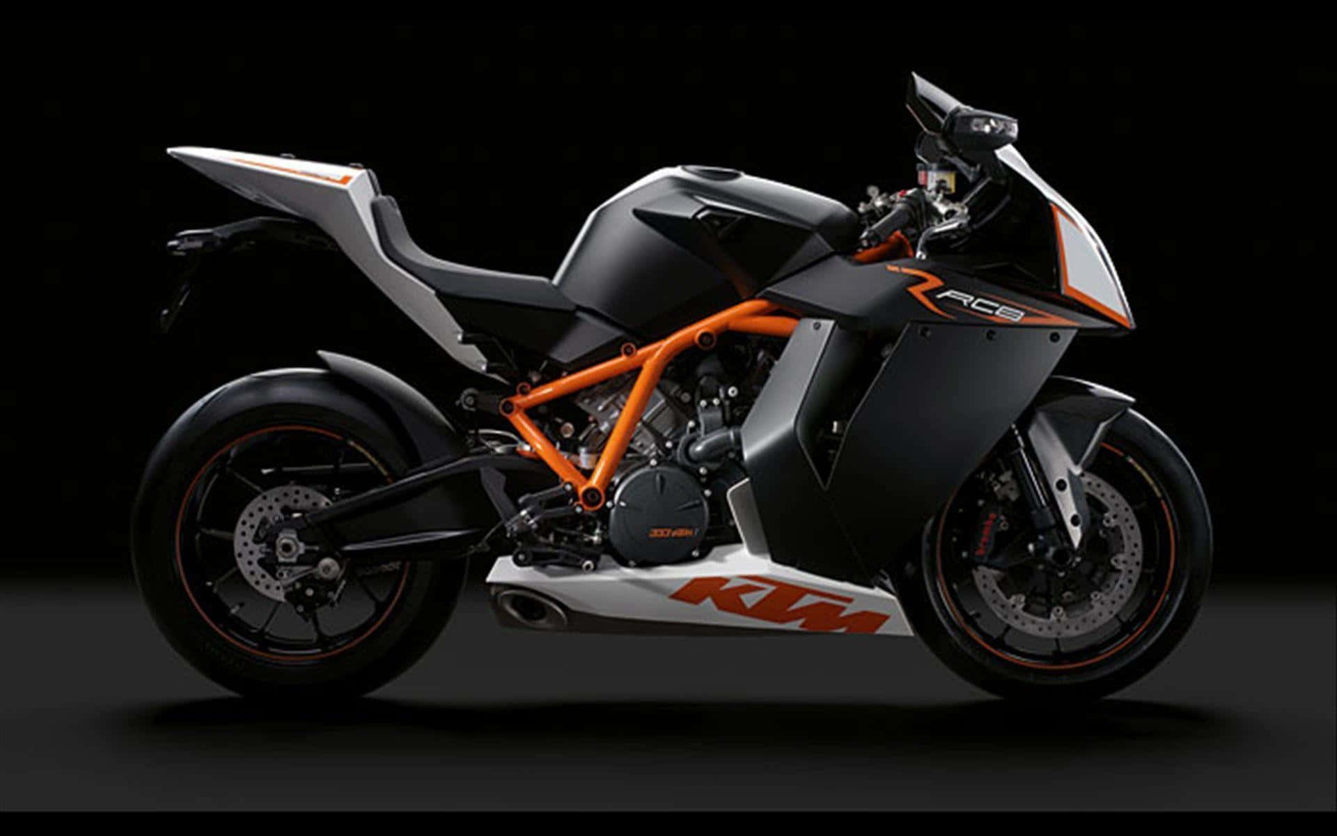 KTM賽車的流線型設計 壁紙 — 一輛時尚的KTM RC8運動電單車，帶有橙色和黑色點綴，在戲劇性的攝影棚燈光下，以深色背景為襯托。