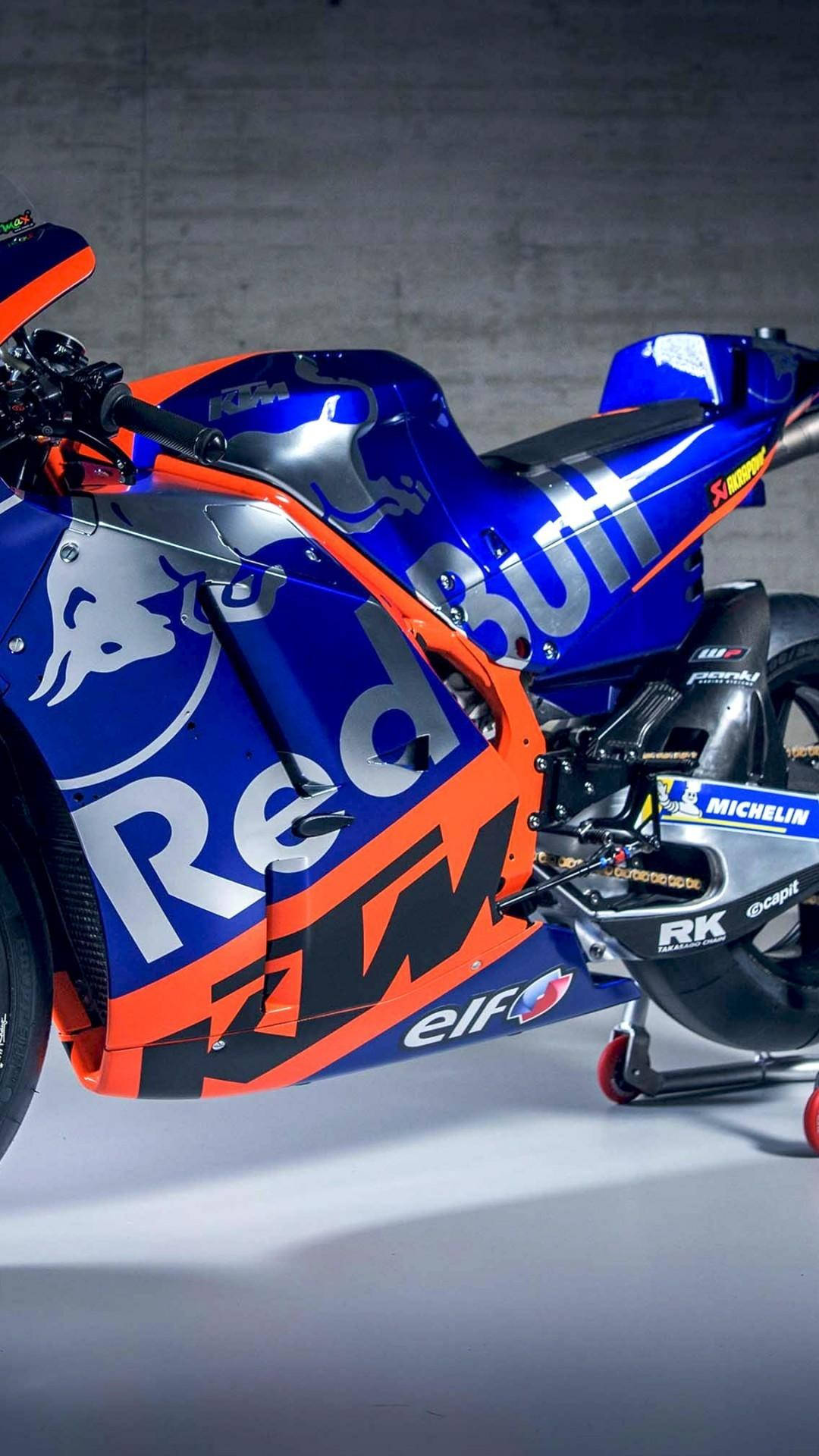 藍橙色Red Bull KTM賽車電單車在攝影棚中，帶有贊助商標誌。