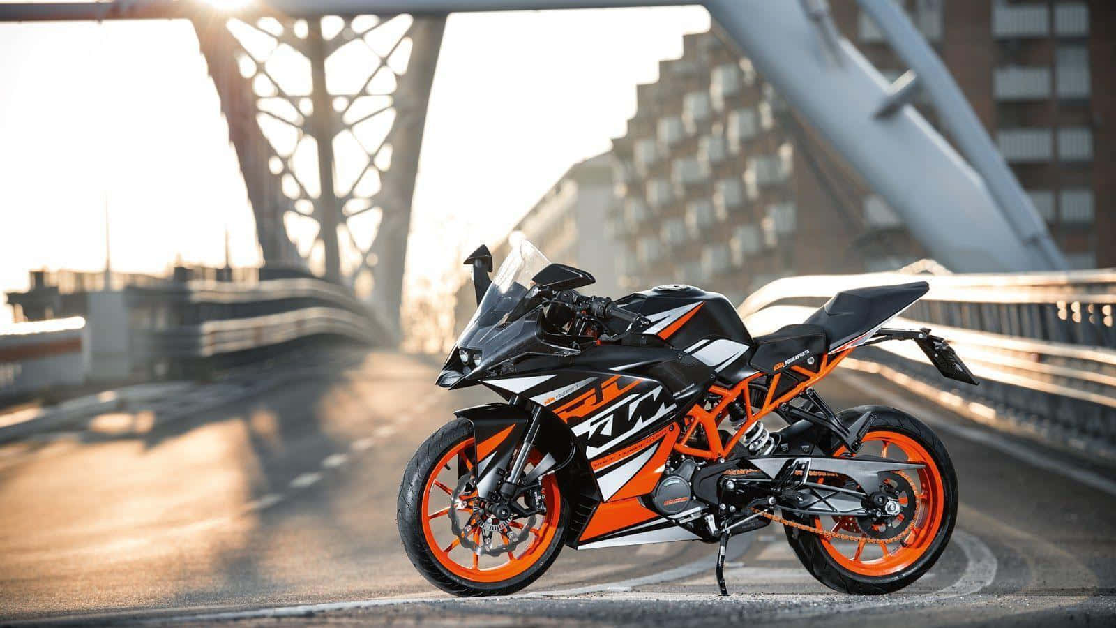KTM RC 圖片 壁紙 — 一架時尚的黑色和橙色KTM運動電單車，在黃金時段停泊在現代橋樑上，背景是城市建築。