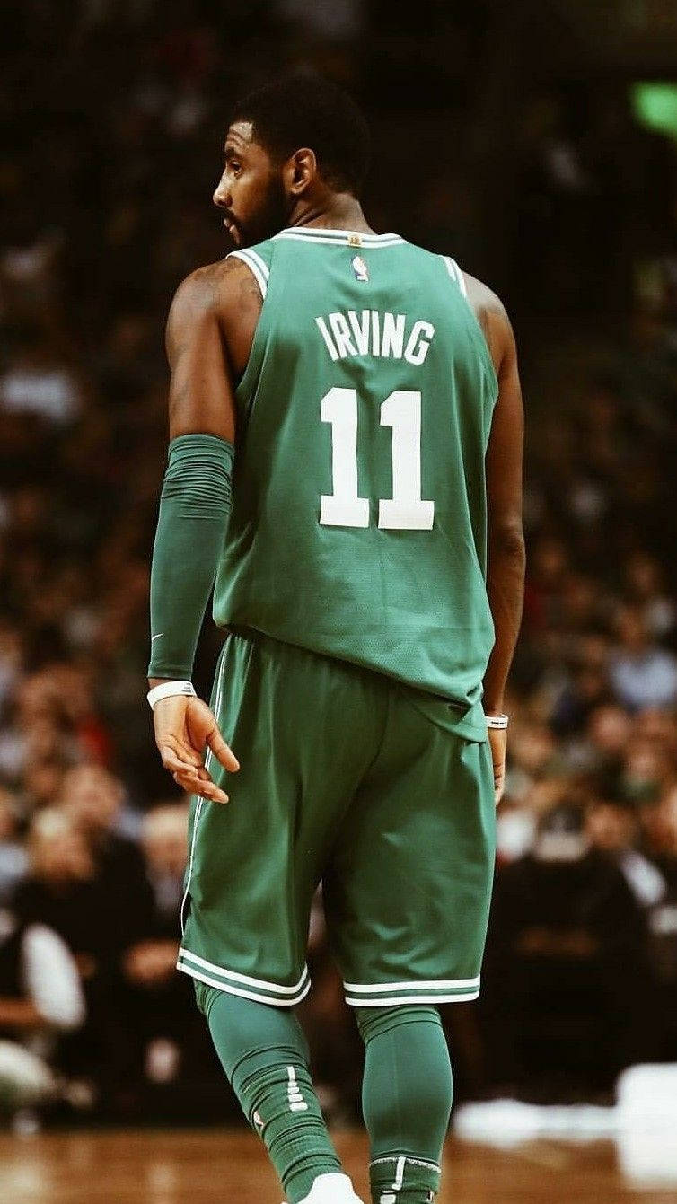 籃球運動員身穿綠色球衣，名字Irving，號碼11，在球場上。