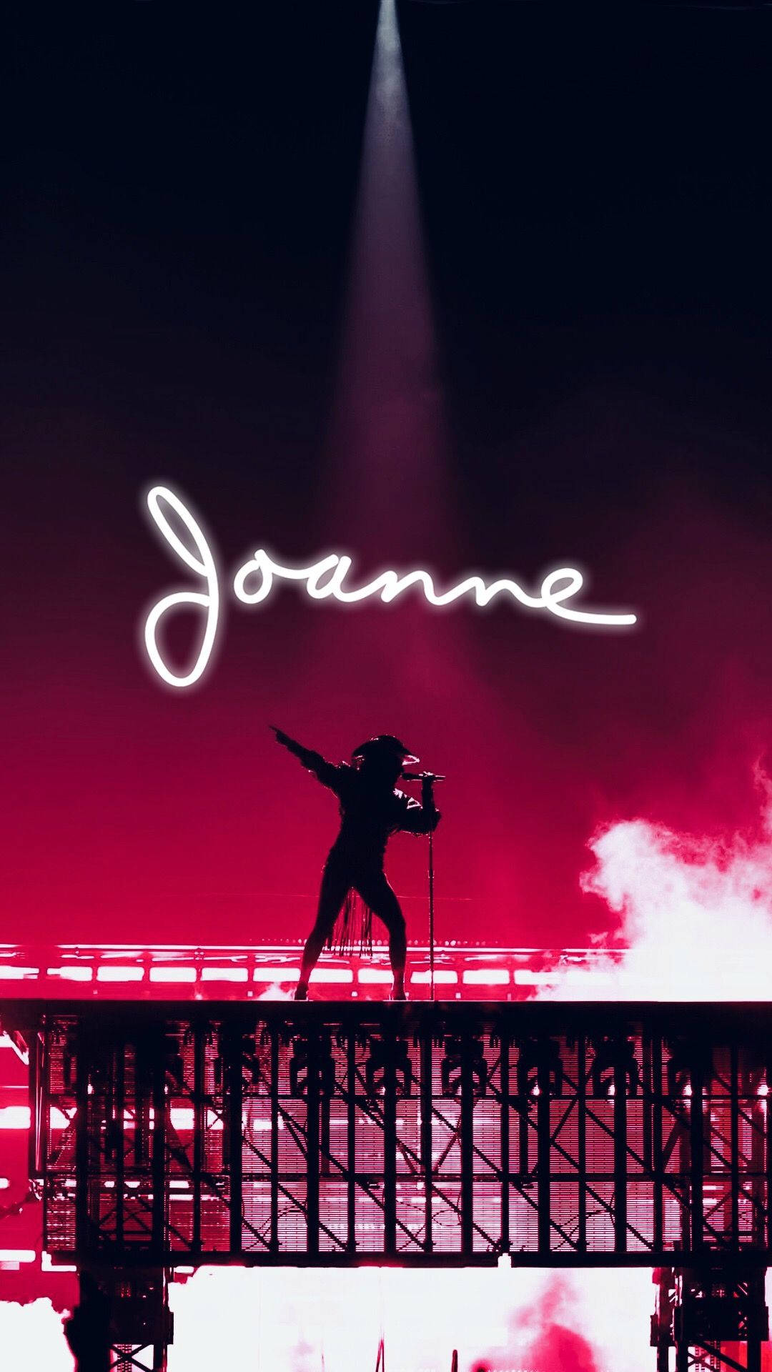 歌手在燈光舞台上表演，'Joanne' 以發光字母呈現。
