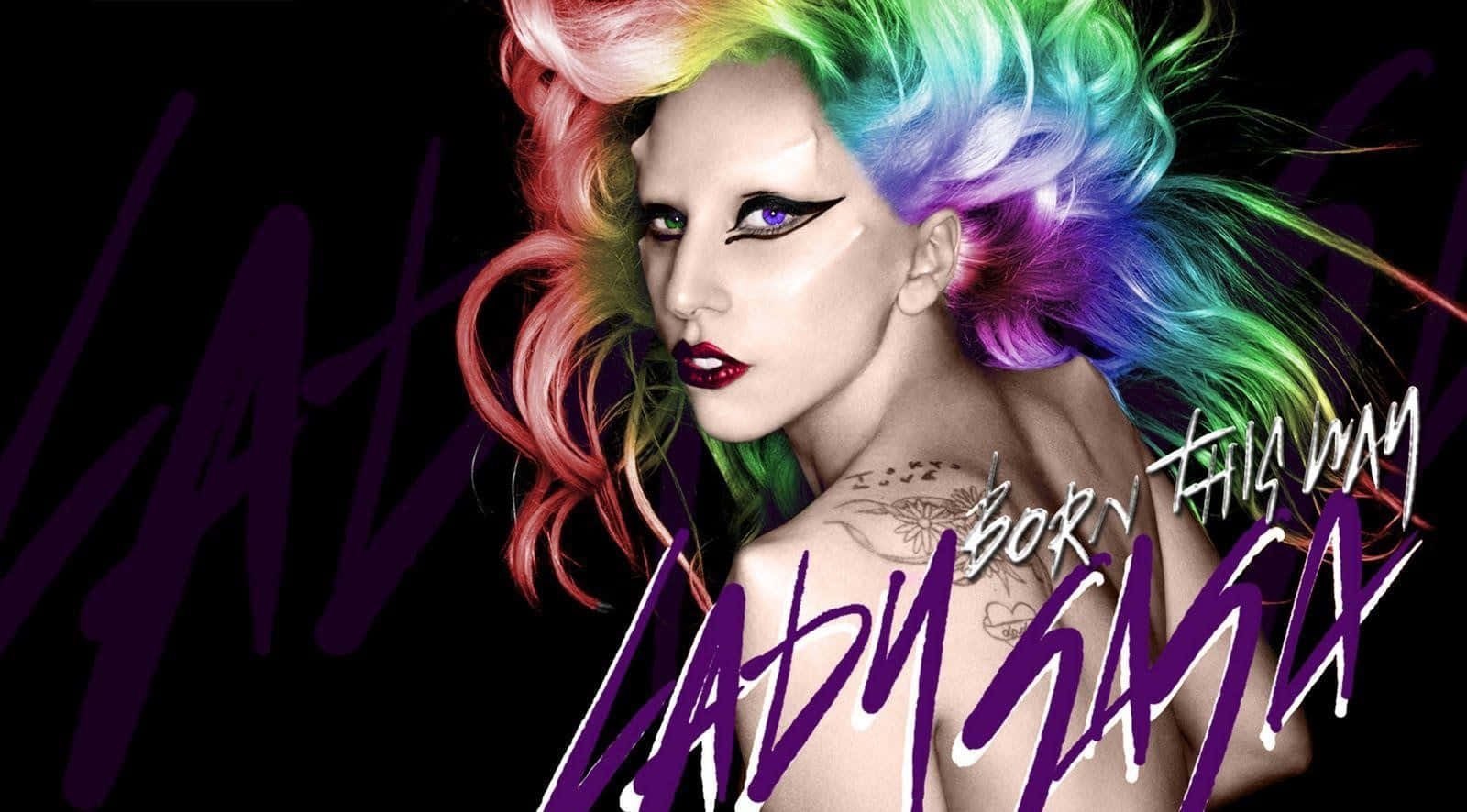Lady Gaga 桌布 壁紙 — Lady Gaga 彩虹頭髮和誇張化妝，在黑色背景前擺姿勢，帶有紫色文字。