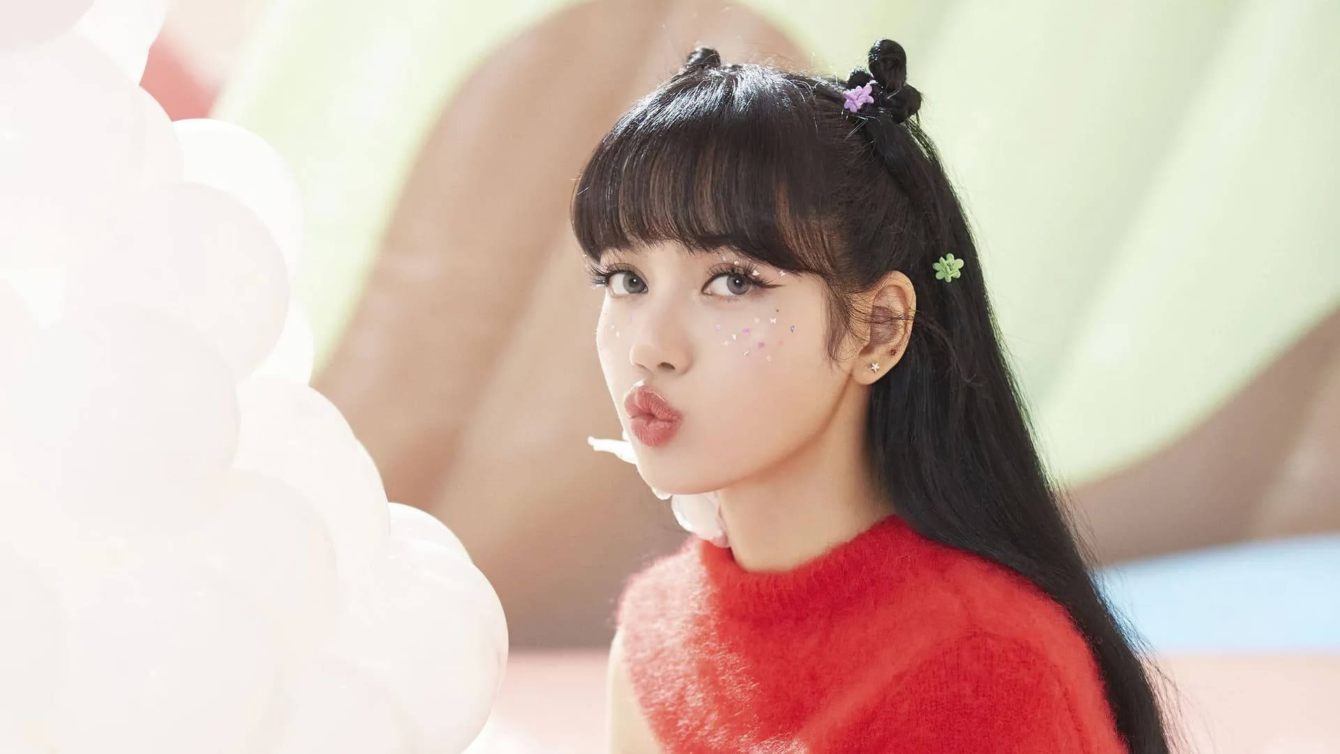 Lalisa Manoban穿紅色毛衣黑pink桌面壁紙 壁紙 — 一位穿著紅色毛衣的年輕女性在一簇白色氣球旁俏皮地嘟起嘴唇。