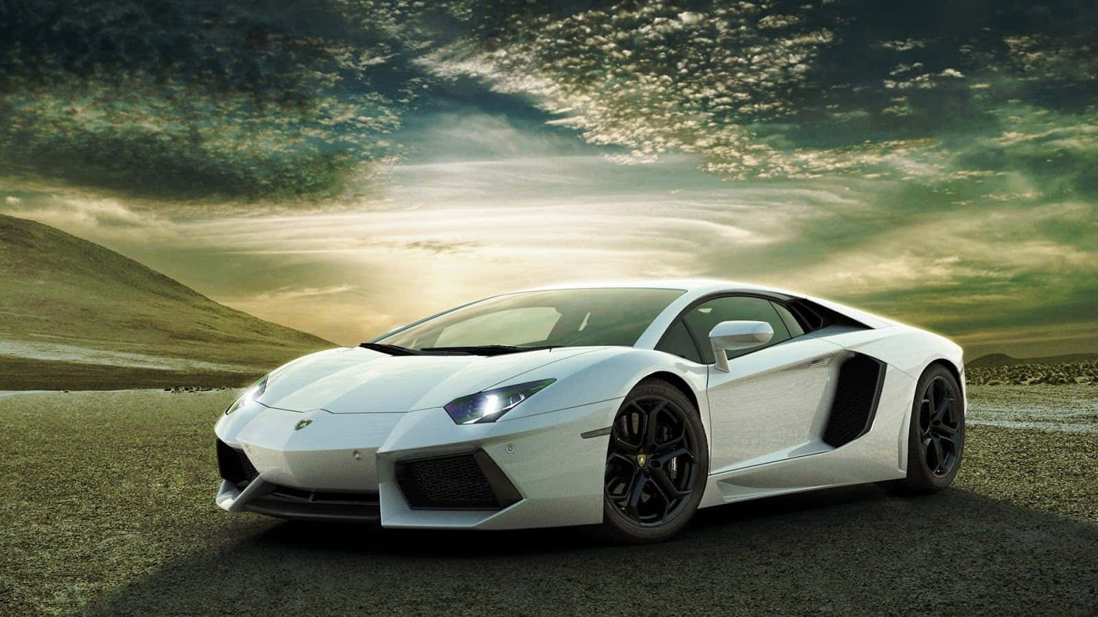 十大跑車：白色Lamborghini Aventador日落背景 壁紙 — 一架時尚的白色林寶堅尼Aventador停泊在碎石路上，背景是日落時分戲劇性的多雲天空。