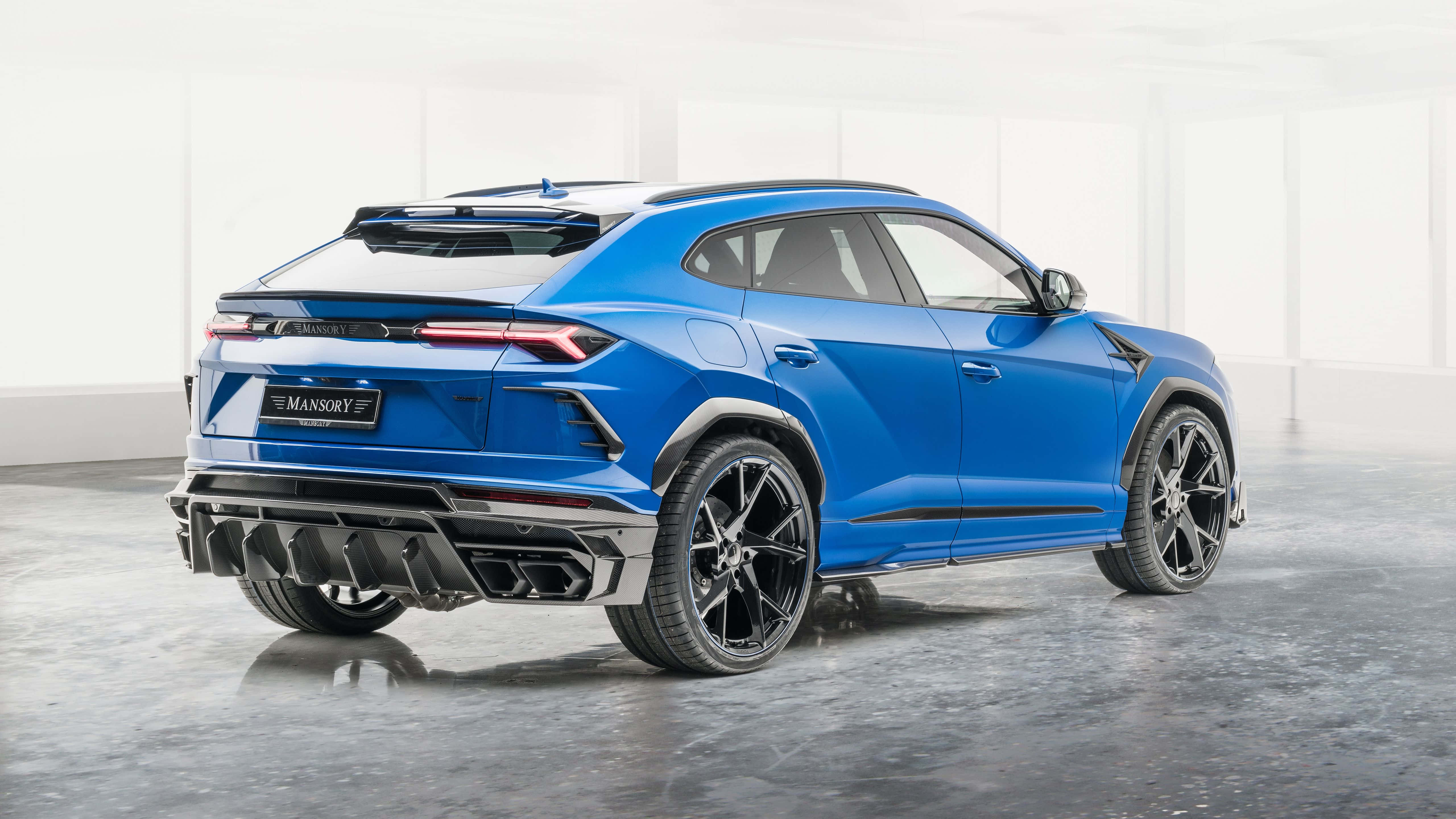 Lamborghini Urus 桌布 壁紙 — 一輛充滿活力的藍色Mansory改裝林寶堅尼Urus SUV在簡約白色工作室中展示，地面為反光混凝土。