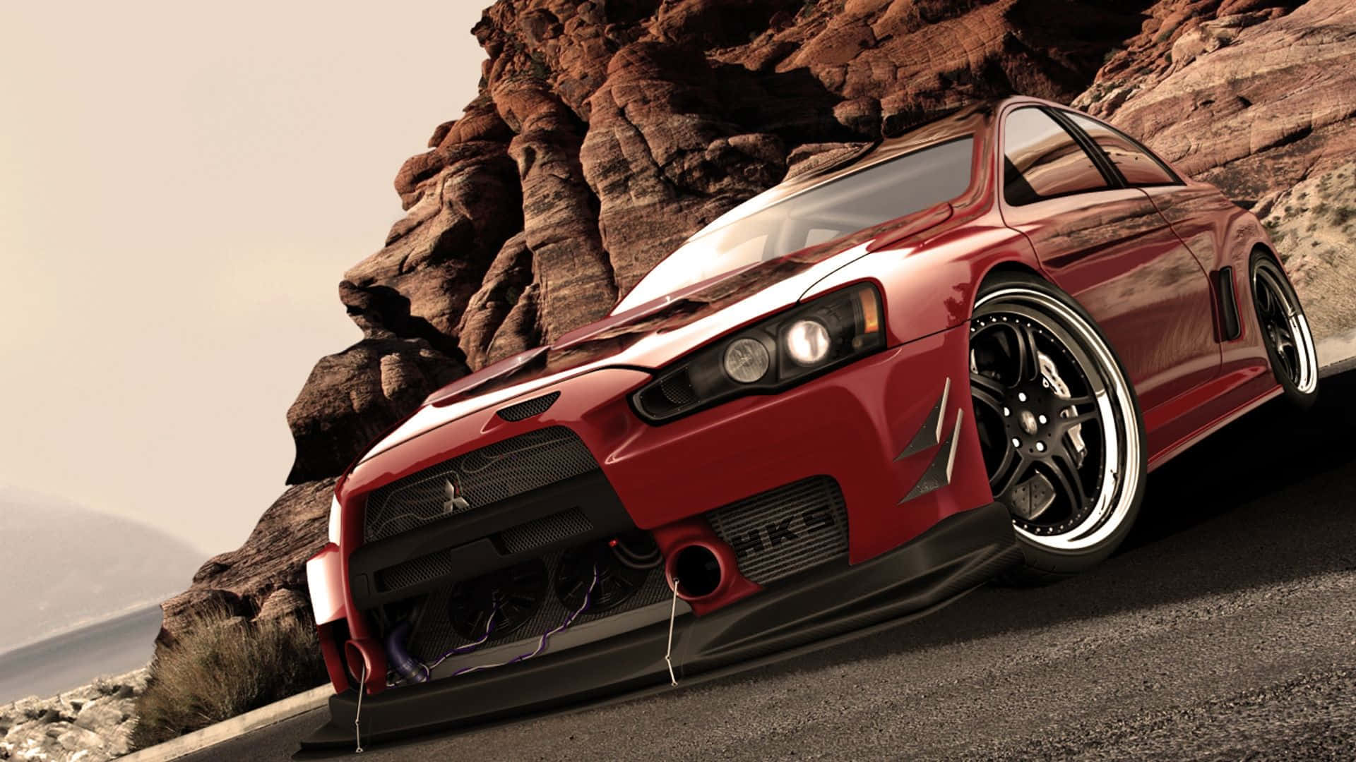 三菱Lancer Evolution 最佳《速度與激情》背景 壁紙 — 一架閃亮紅色跑車配備定制輪圈，停泊在崎嶇沙漠岩石 formations 旁邊的蜿蜒道路上。