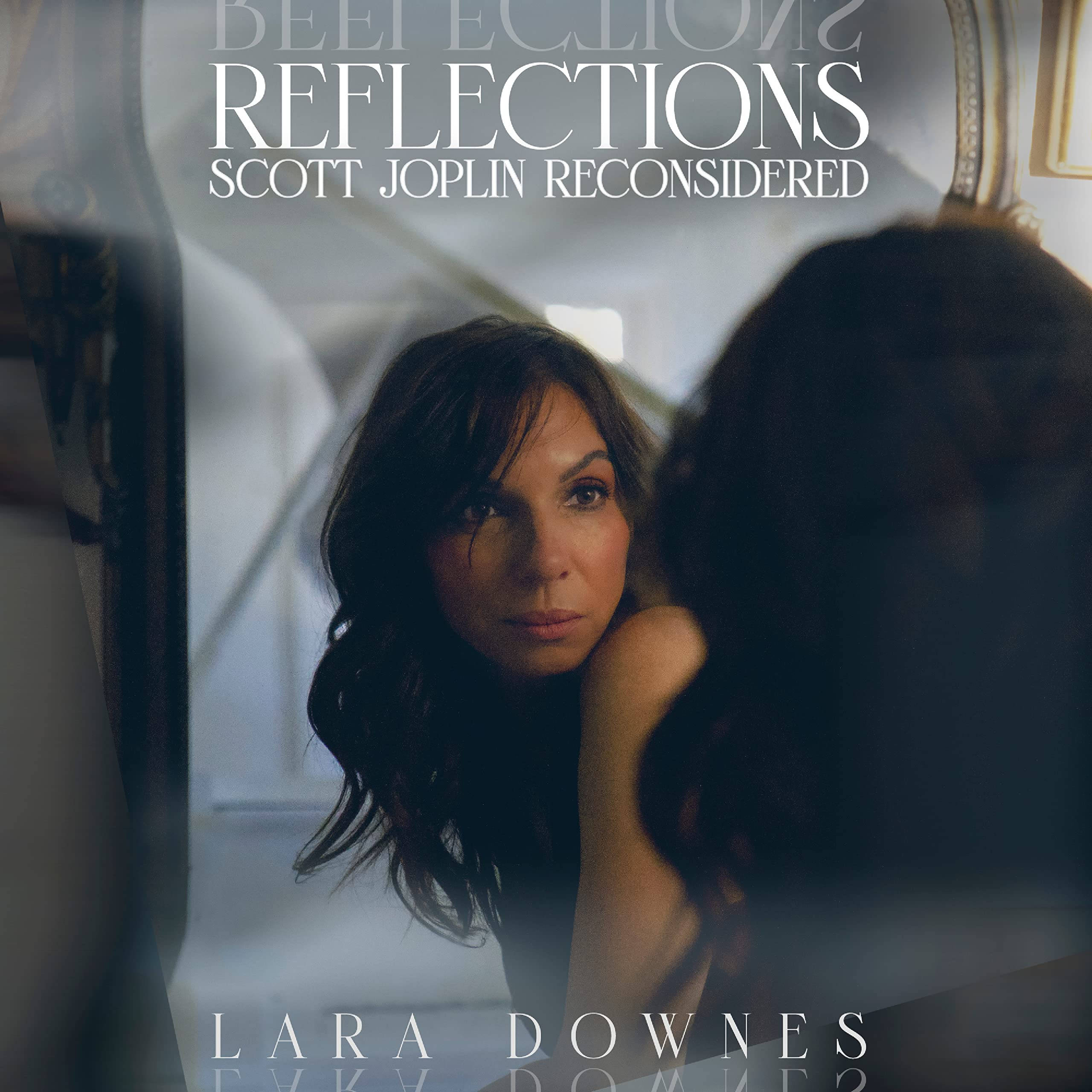 Lara Downes《Reflections》專輯封面：重新詮釋Scott Joplin 壁紙 — 一位女士在柔和光線和優雅框架的鏡子中若有所思地凝視著自己的倒影。
