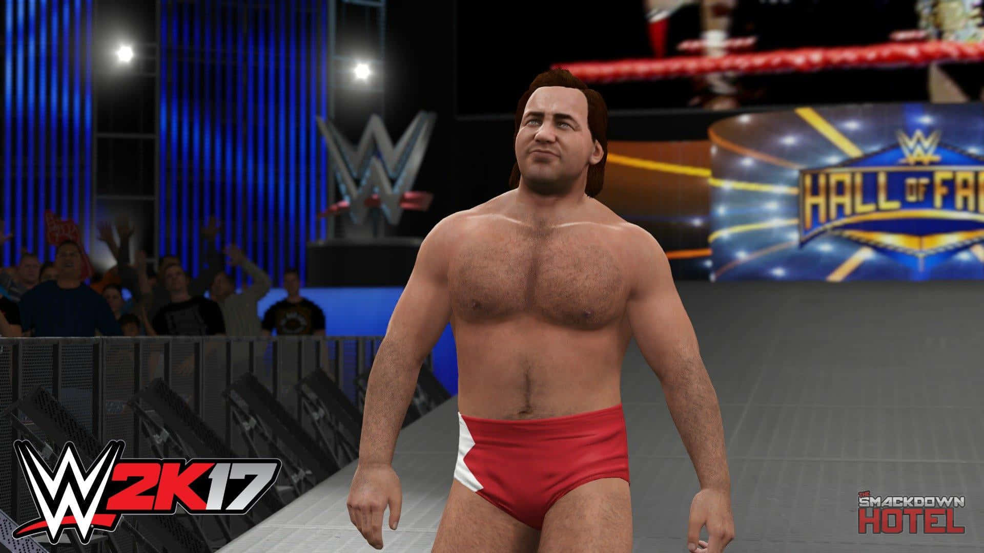 美國職業摔角手Larry Zbyszko WWE 2K17 壁紙 — 一位肌肉發達的摔角手穿著紅色短褲，自信地走過WWE競技場，場內有發光的藍色燈光和歡呼的粉絲。