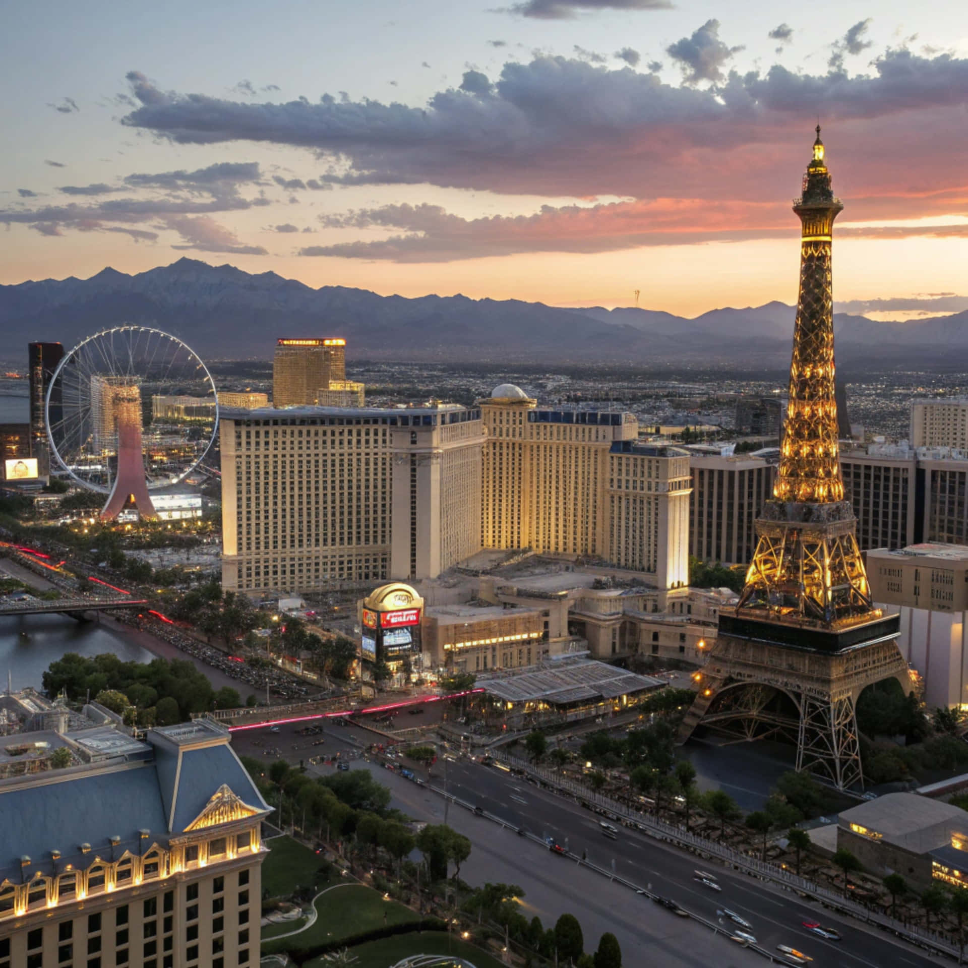 Las Vegas Skyline 壁紙 — 黃昏時分拉斯維加斯的鳥瞰圖，艾菲爾鐵塔複製品和高滾輪摩天輪在色彩繽紛的天空下閃耀。