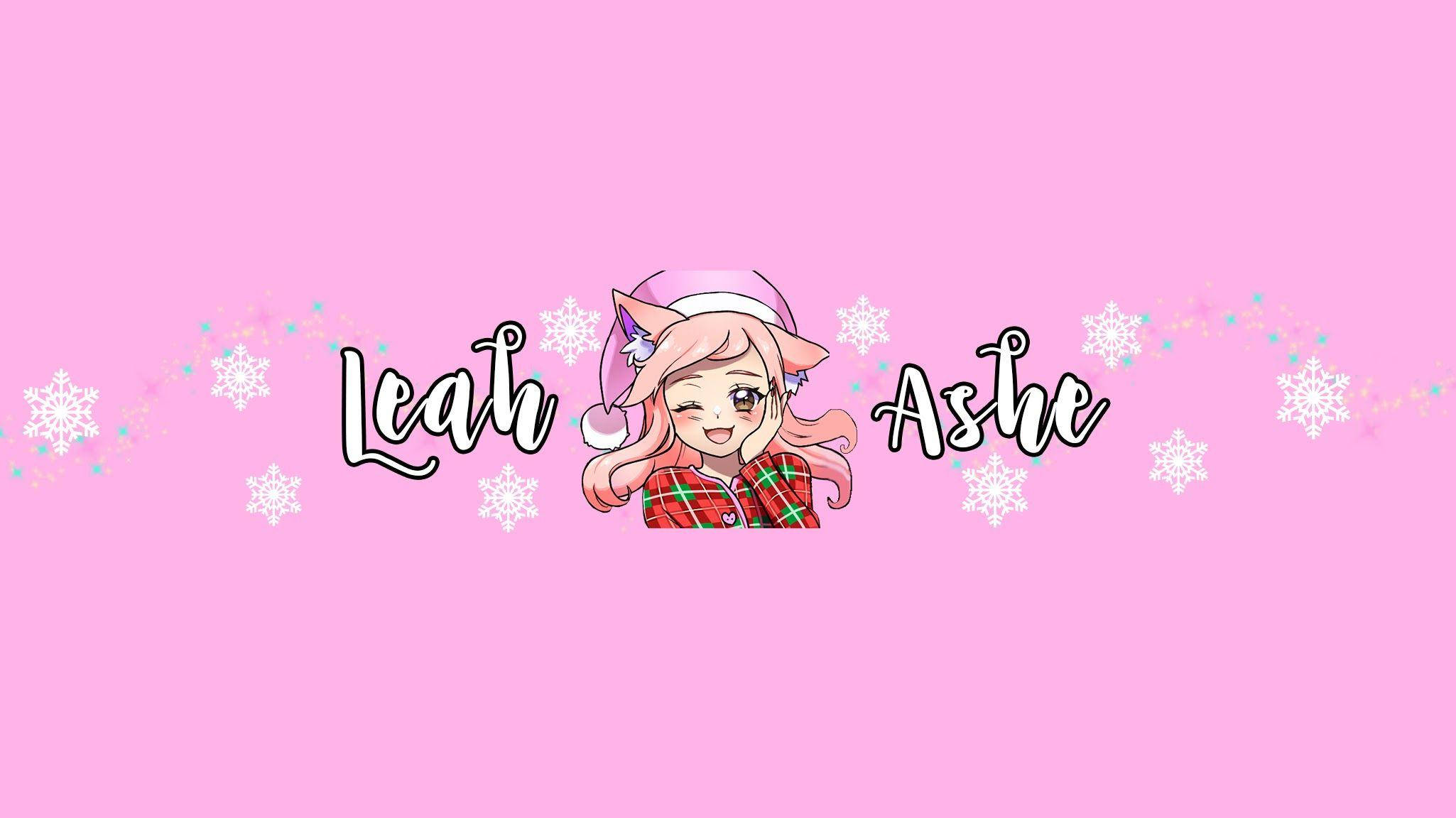 Leah Ashe 高畫質封面照 壁紙 — 一個戴著貓耳、粉紅色頭髮的開朗動畫女孩，在柔和的粉紅色背景前，戴著節日冬帽微笑，背景有雪花和閃閃發光的亮片。