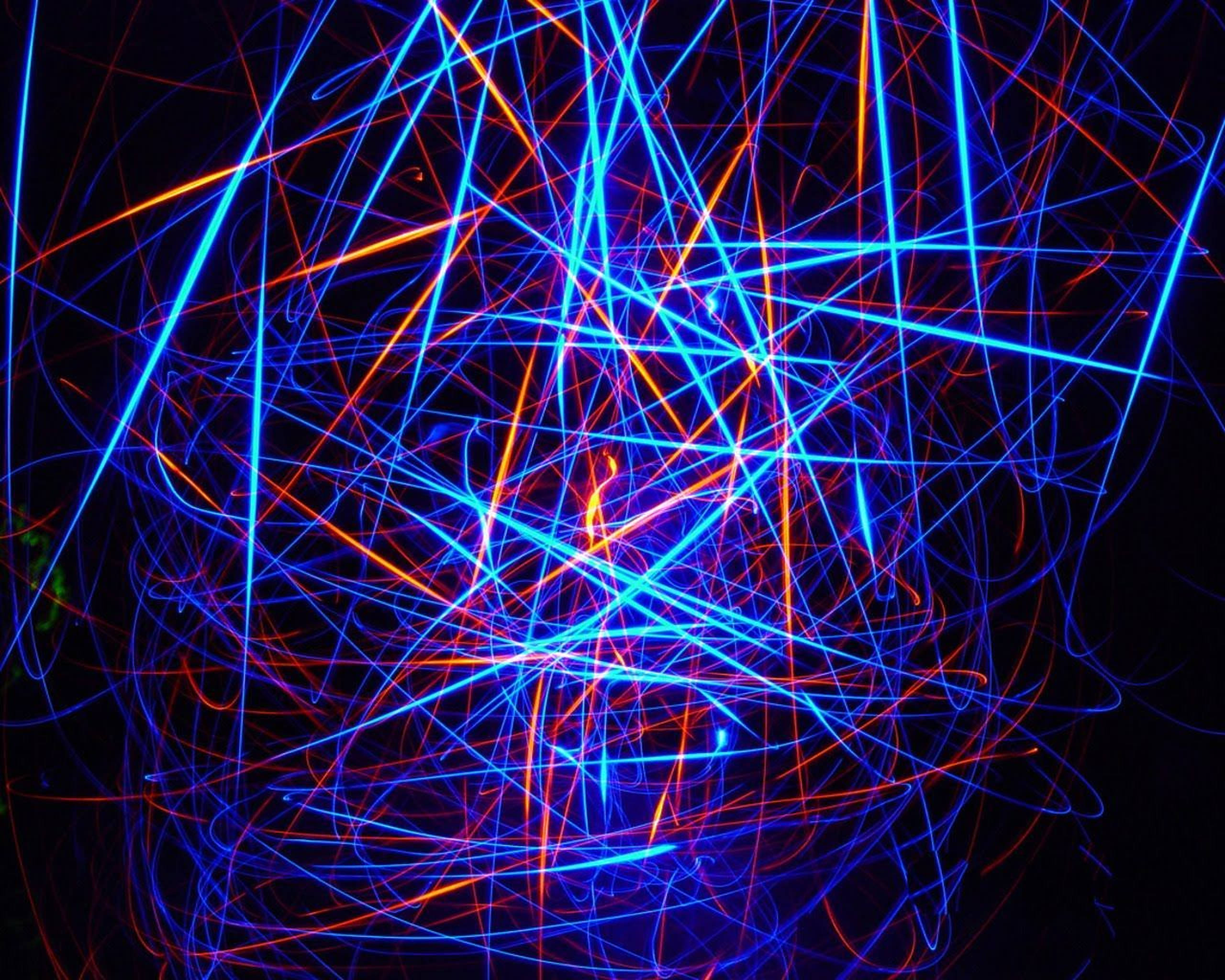 夜間LED燈光景觀 壁紙 — 鮮豔的藍色和橙色光軌在黑色背景上交錯，形成混亂的抽象圖案。