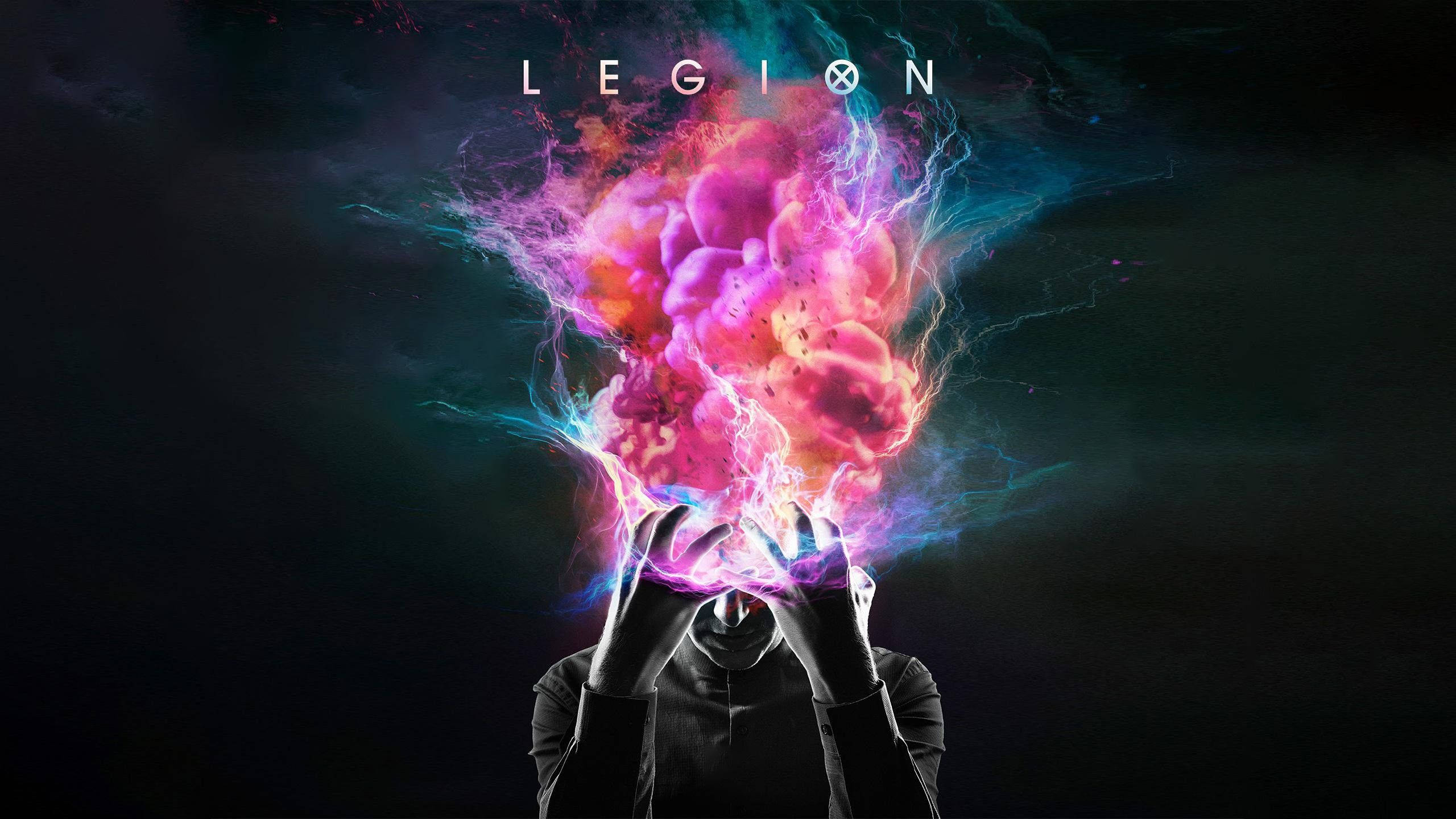 Legion（第一季）抽象頭部爆裂 1440p 遊戲背景 壁紙 — 一個剪影人物抱著頭，在黑暗背景中，他們的頭骨爆發出充滿活力的粉紅色和藍色能量爆炸。