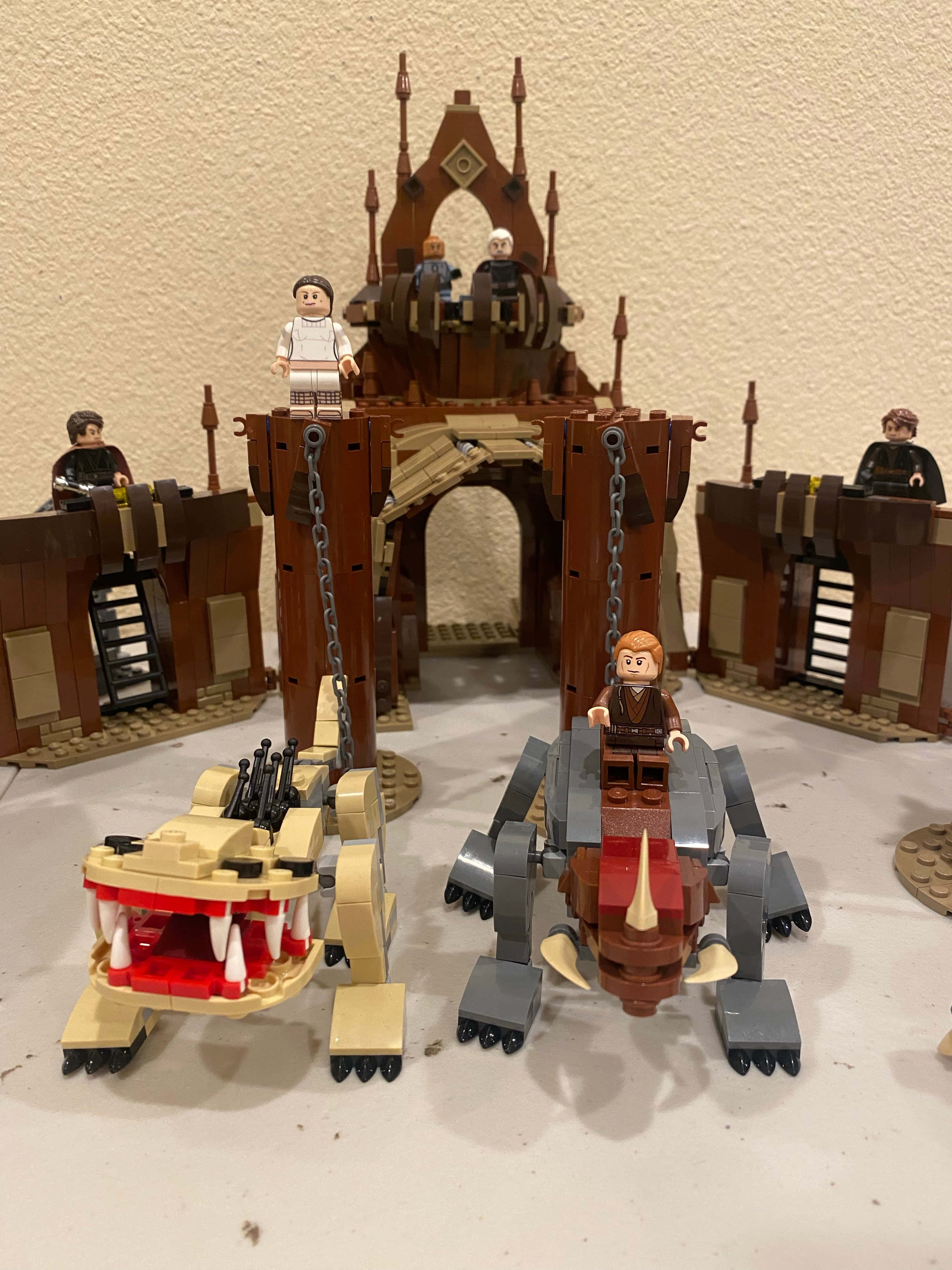 The Geonosian Arena 桌布 壁紙 — LEGO Star Wars 城堡連同人仔及兩部詳細的飛梭賽車，放置在平坦表面上。
