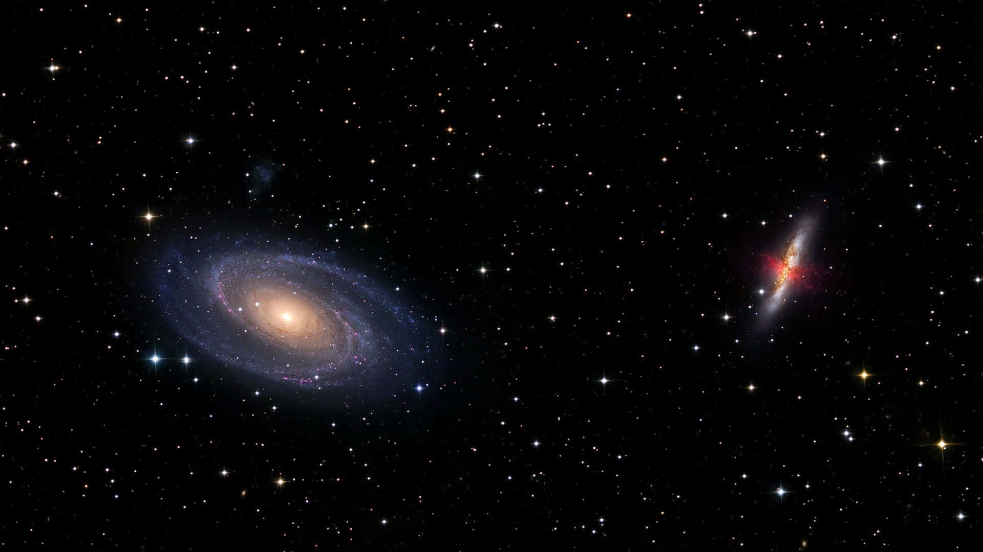 兩個螺旋星系在深邃太空中發光，周圍環繞著無數恆星。