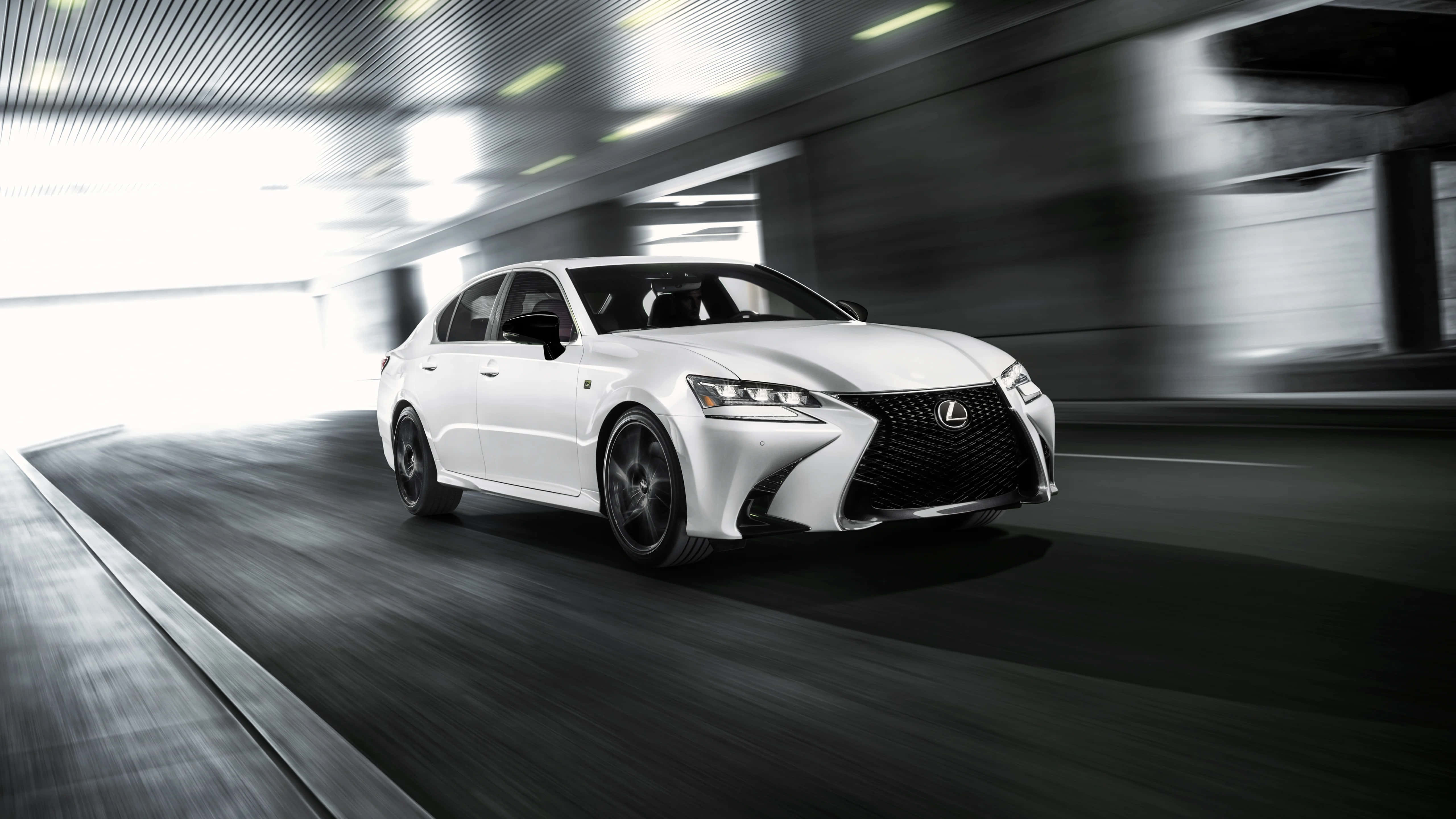 Lexus Gs F 桌布 壁紙 — 一輛時尚的白色Lexus房車在現代隧道中疾馳，動態模糊強調了速度。