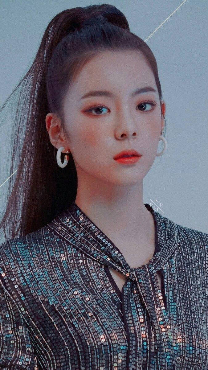 Lia 簡約妝容造型壁紙 壁紙 — 一位深色頭髮高馬尾的年輕女性，穿著閃閃發光的亮片上衣和大圈耳環，背景為柔和的灰色。