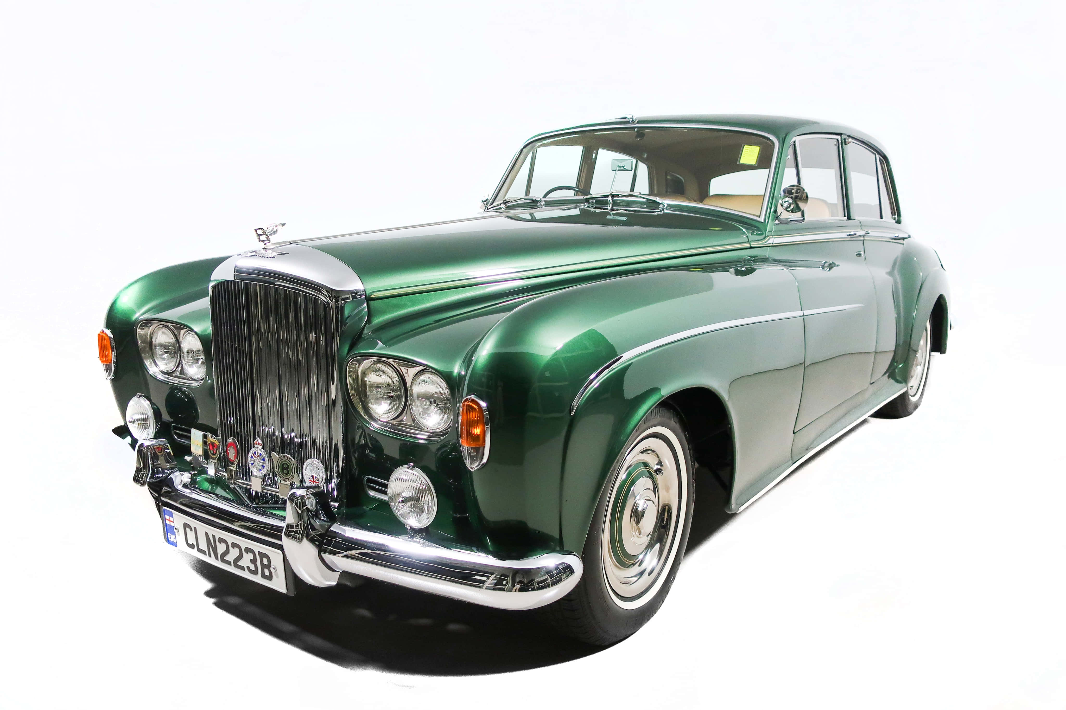 Bentley S3 桌布 壁紙 — 一輛光澤的綠色復古賓利轎車，帶有鍍鉻裝飾和白色輪胎，置於純白背景前。
