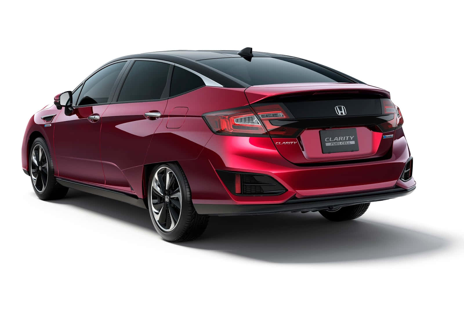 Honda Clarity 桌布 壁紙 — 一輛亮紅色本田Clarity插電式混合動力轎車，從後方四分之三角度拍攝，背景為乾淨的白色攝影棚。