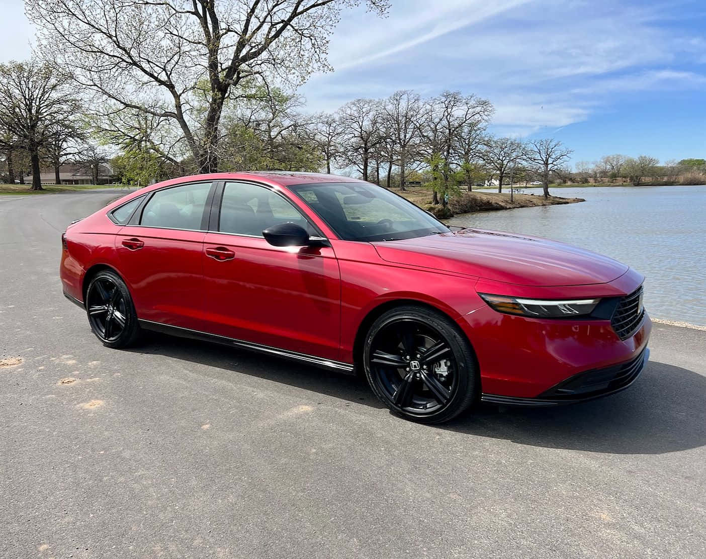 Honda Accord 桌布 壁紙 — 一架亮紅色本田房車配黑色輪圈，停泊在平靜湖泊旁的瀝青路面上，天空湛藍明亮。