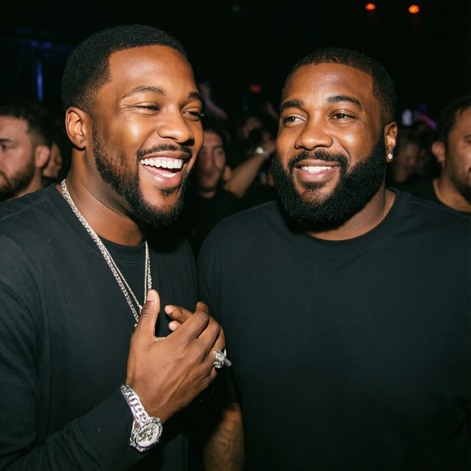 Meek Mill 桌布 壁紙 — 兩位微笑的黑襯衫男士在昏暗的派對中一起大笑，背景有發光的燈光。
