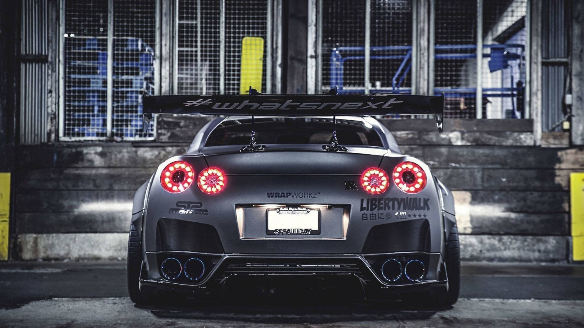 訂製灰色日產GT-R，紅色尾燈，停放在工業車庫。