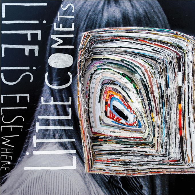 Life Is Elsewhere《Little Comets》專輯封面 壁紙 — 一層層報紙剪報形成旋轉螺旋，在深色紋理背景上構成鮮豔的眼睛，旁邊有粗體白色文字。