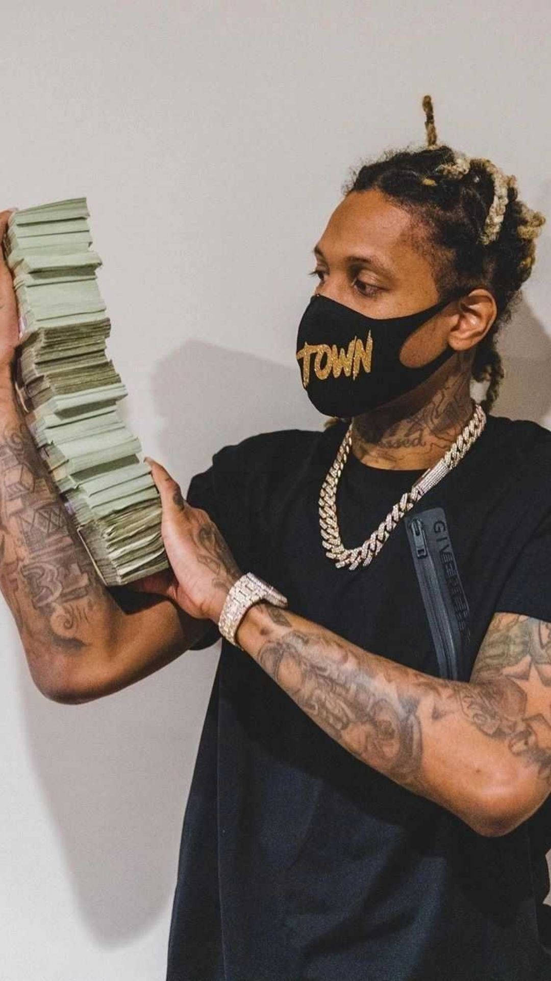 Lil Durk 手持現金 壁紙 — 一個紋身男子戴著黑色口罩，拿著一大疊現金，背景是純白牆壁。