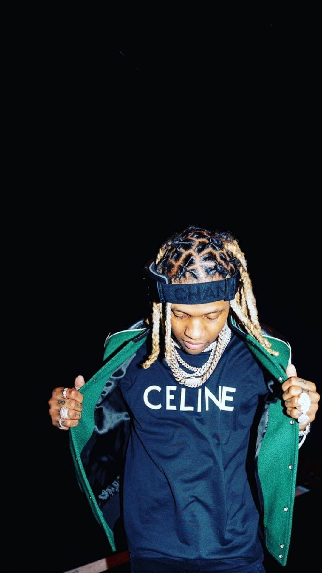 Lil Durk 拿著綠色夾克 壁紙 — 一名年輕男子梳著辮子，戴著 Chanel 頭帶，在黑色背景前拉開綠色外套。