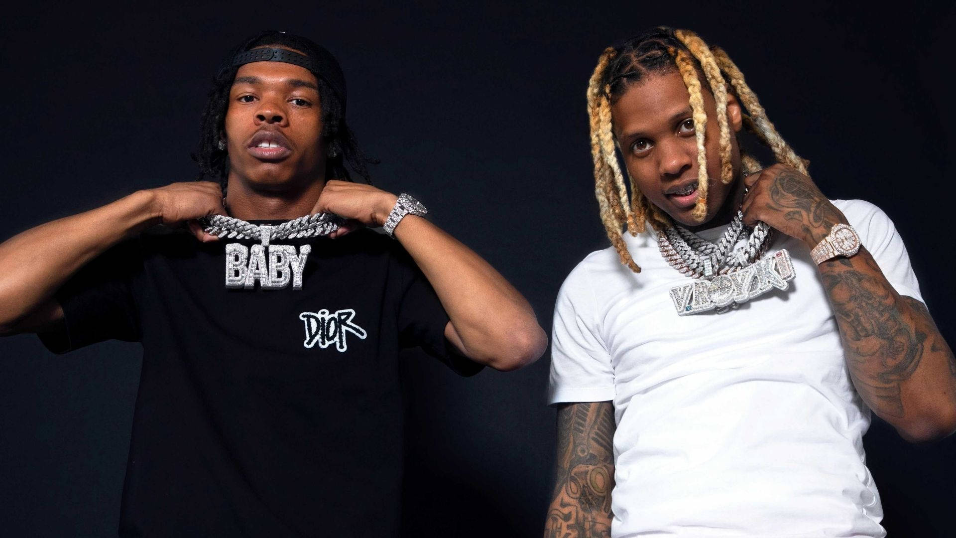 Lil Durk 與 Lil Baby 壁紙 — 兩位時尚饒舌歌手在深色背景下自信擺姿勢，展示大膽珠寶和紋身。