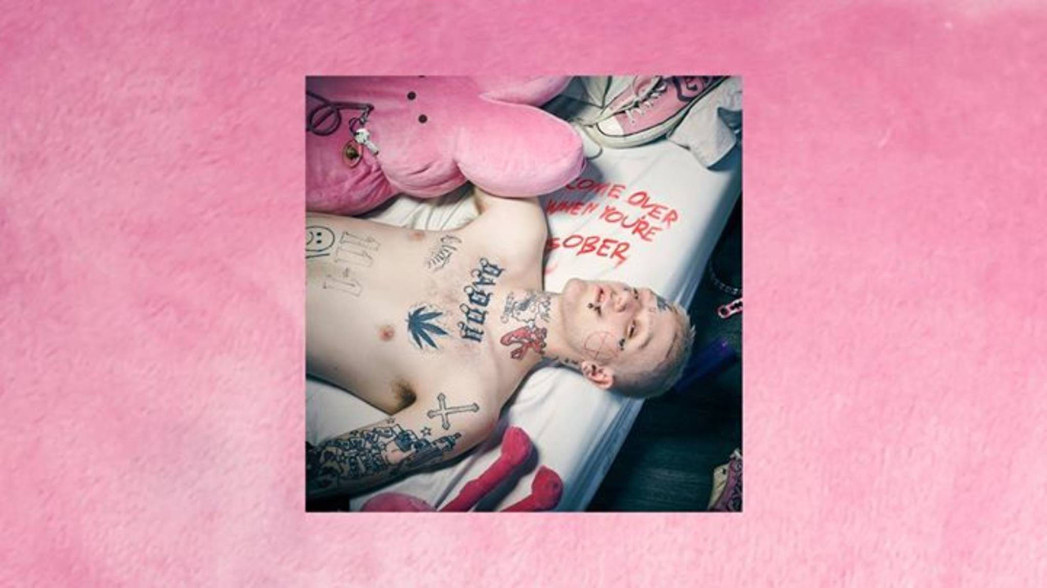 立即聆聽Lil Peep經典《Pink》專輯 壁紙 — 一個有紋身的男人躺在床上，周圍有粉紅色毛絨玩具和手寫文字，背景是柔和的粉紅色。