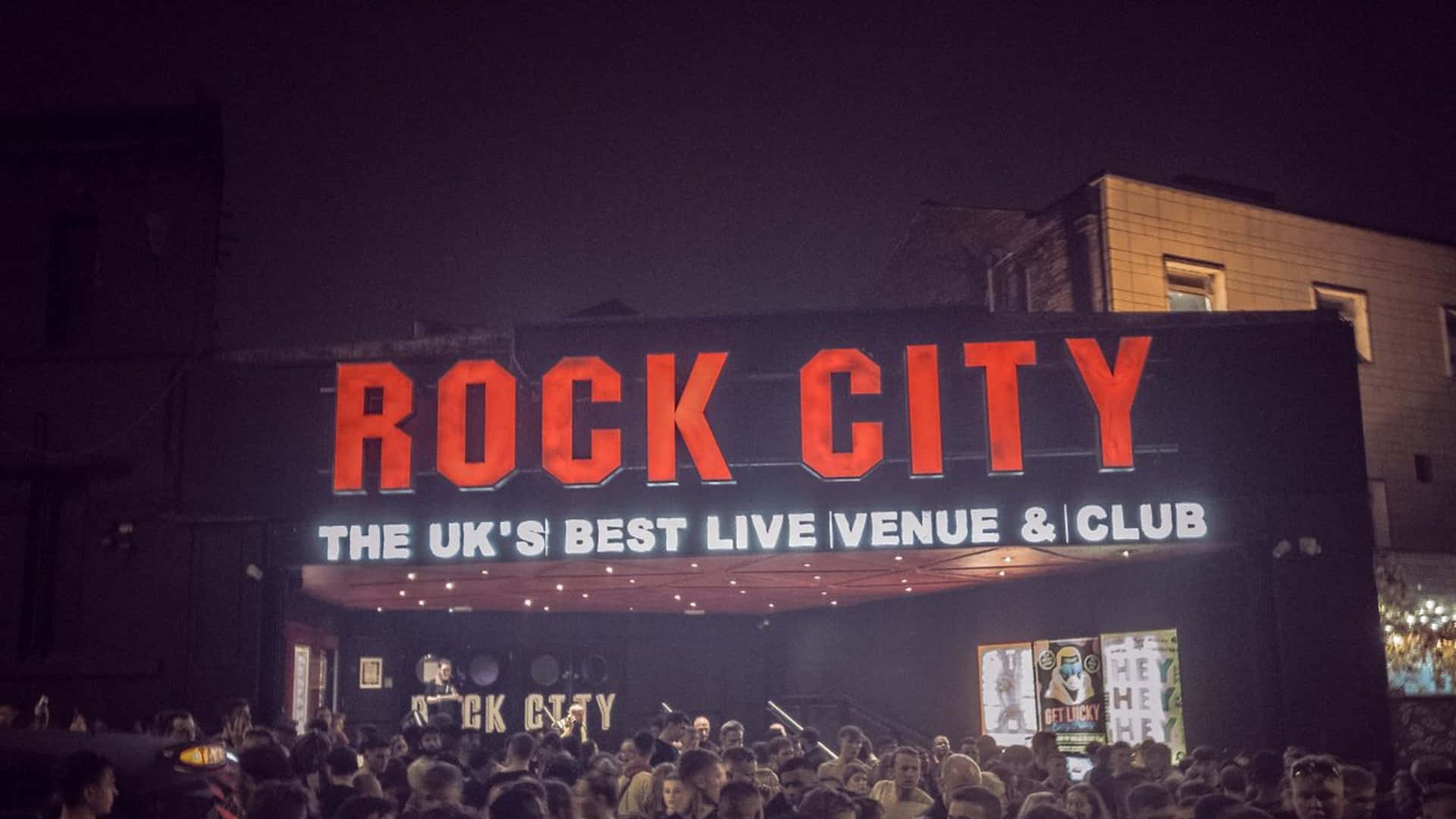 Rock City 現場音樂場地外的夜間人群，帶有發光的紅色標誌。