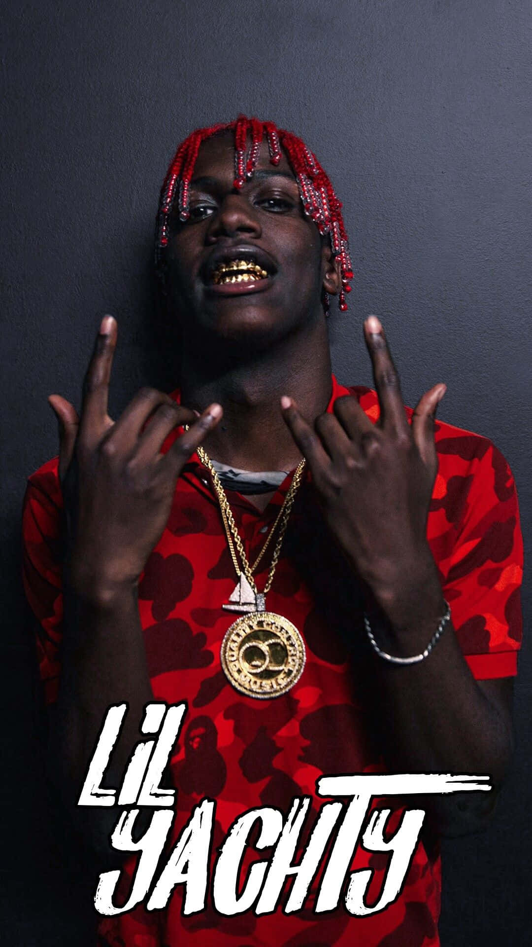Lil Yachty 展現強大氣勢 壁紙 — Lil Yachty 自信地擺姿勢，露出金牙和紅色辮子，背景是深灰色牆壁，身穿紅色迷彩襯衫和金色鏈條。