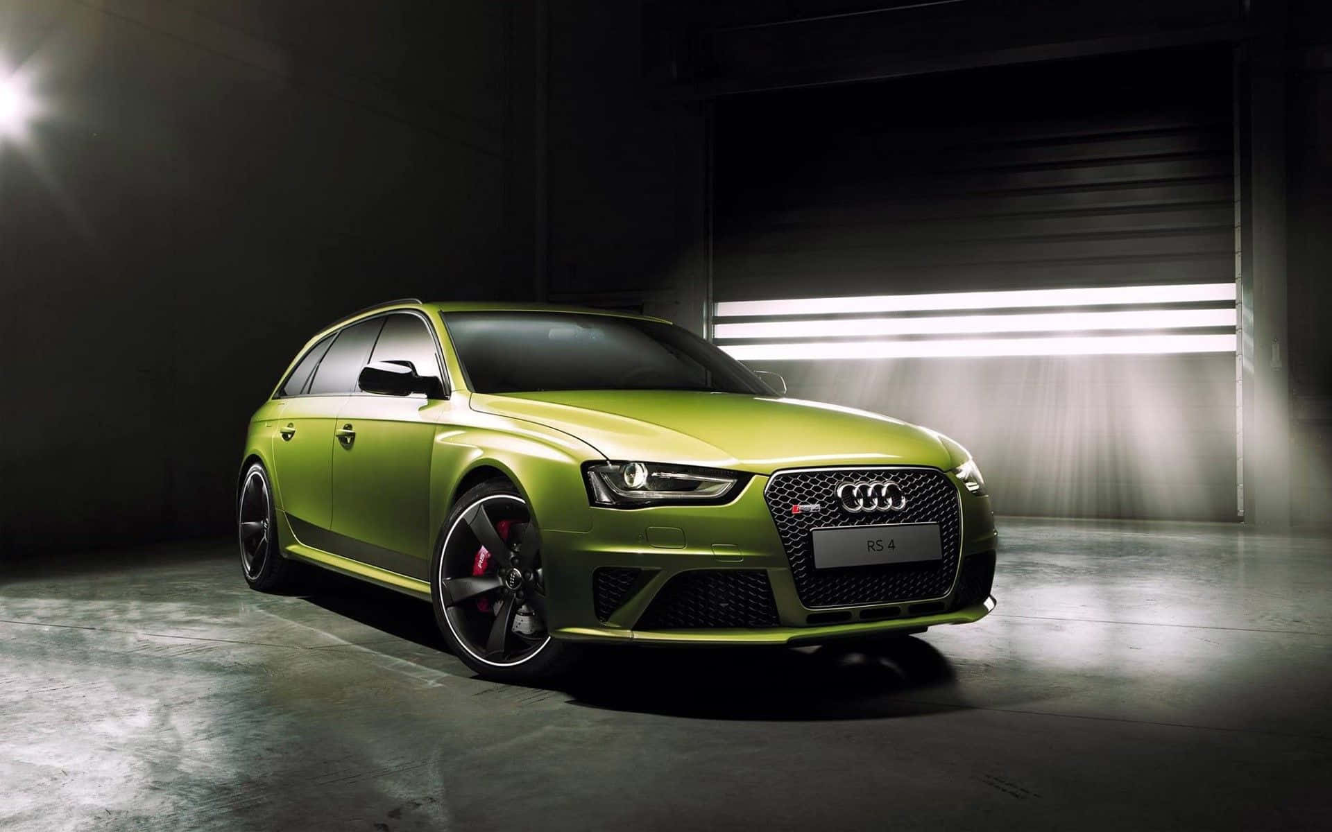Audi Rs5 桌布 壁紙 — 一輛充滿活力的青檸綠色奧迪RS4旅行車在黑暗的工業車庫中，在戲劇性的工作室燈光下閃閃發光。