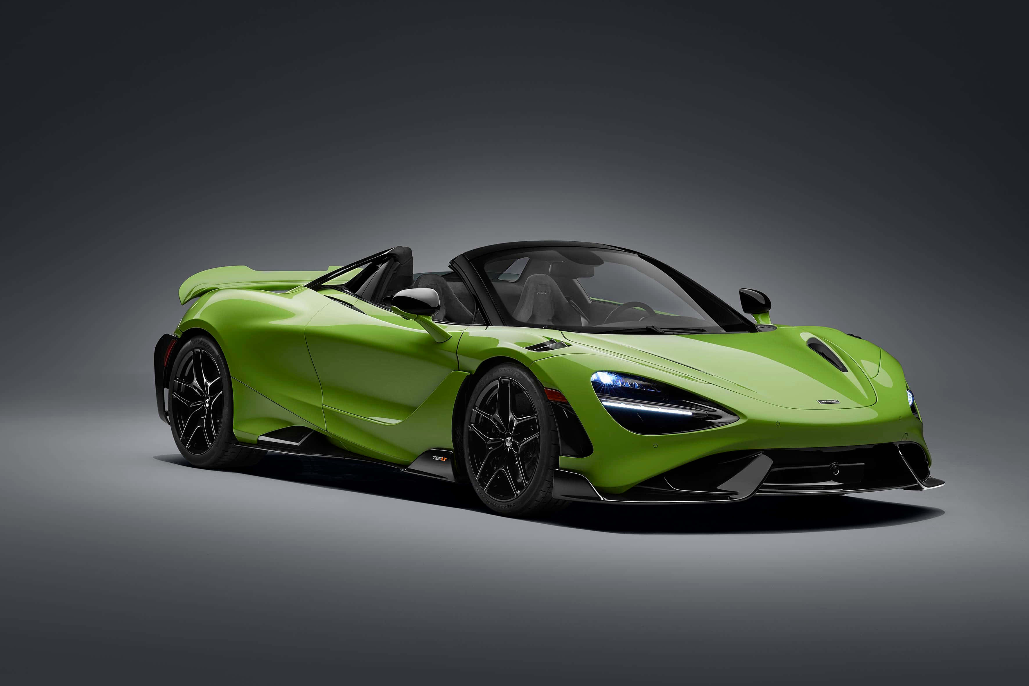 Mclaren 765lt 桌布 壁紙 — 一輛充滿活力的青檸綠色McLaren 720S Spider開篷跑車，帶有黑色飾邊和發光車頭燈，在深色漸變工作室背景前擺拍。