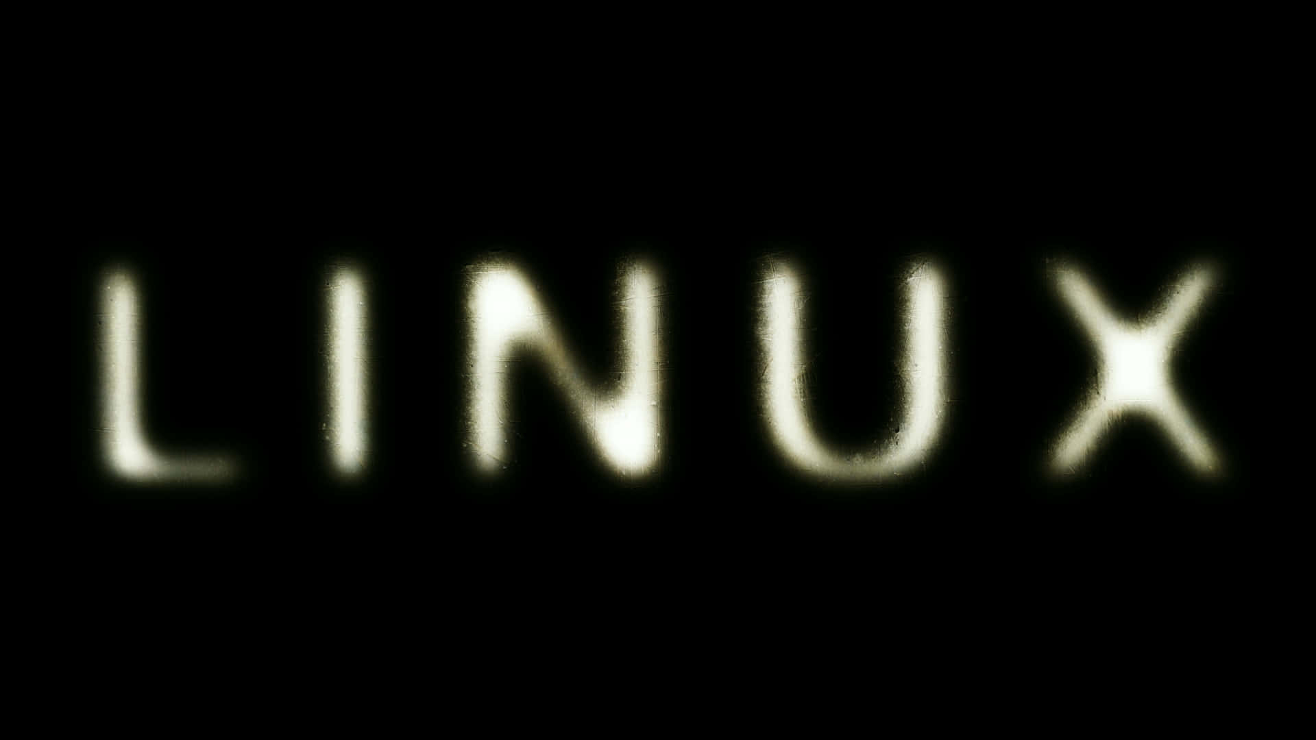 Linux 的量子躍進 壁紙 — LINUX 這個字在深黑色背景上以淡黃色柔和發光，帶有微妙的模糊效果。