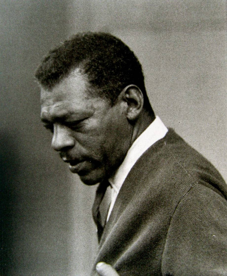 Little Walter 黑白舊照 壁紙 — 一位身穿西裝的男子低頭表情嚴肅的黑白肖像。
