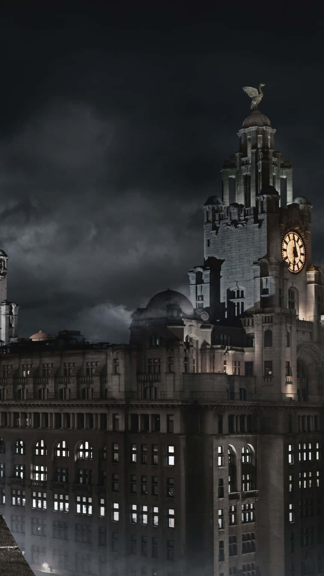 利物浦大廈在夜間亮燈，伴隨暴風雲和水面倒影
