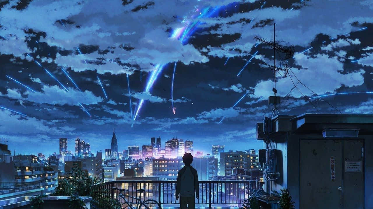 你的名字 Lo Fi 桌面 壁紙 — 一個孤獨的身影站在屋頂陽台上，凝視著下方充滿活力的城市景觀，藍色光線穿過多雲的夜空傾瀉而下。