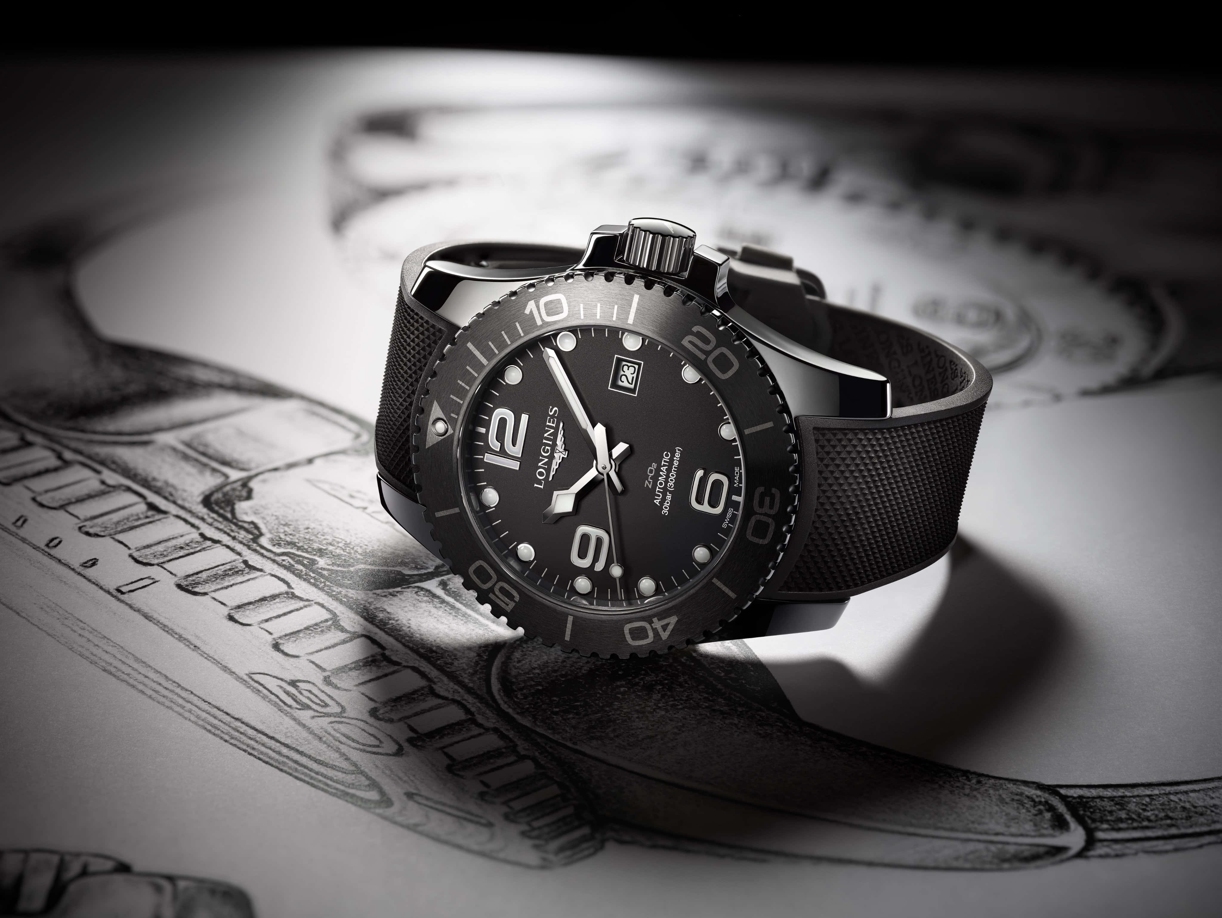 高級 Longines Hydroconquest 腕錶特寫，置於素描本上 壁紙 — 一隻時尚的黑色浪琴手錶放置在詳細的技術圖紙上，帶有戲劇性的聚光燈效果。