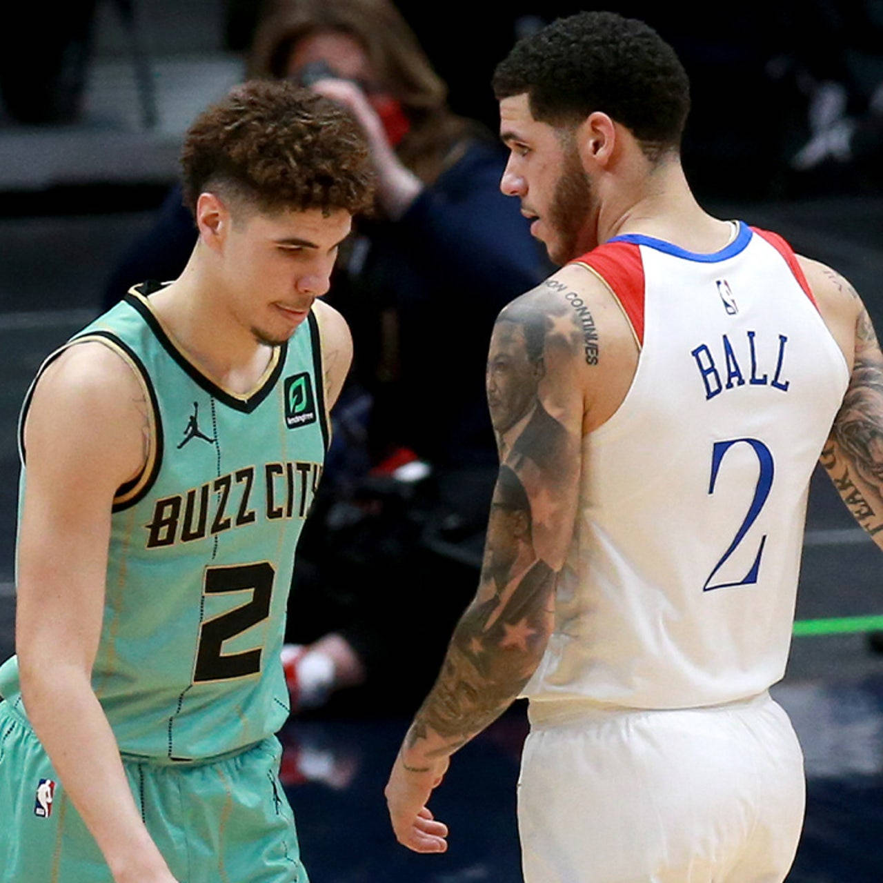 兩名身穿球衣的NBA籃球運動員在比賽中激烈交談。