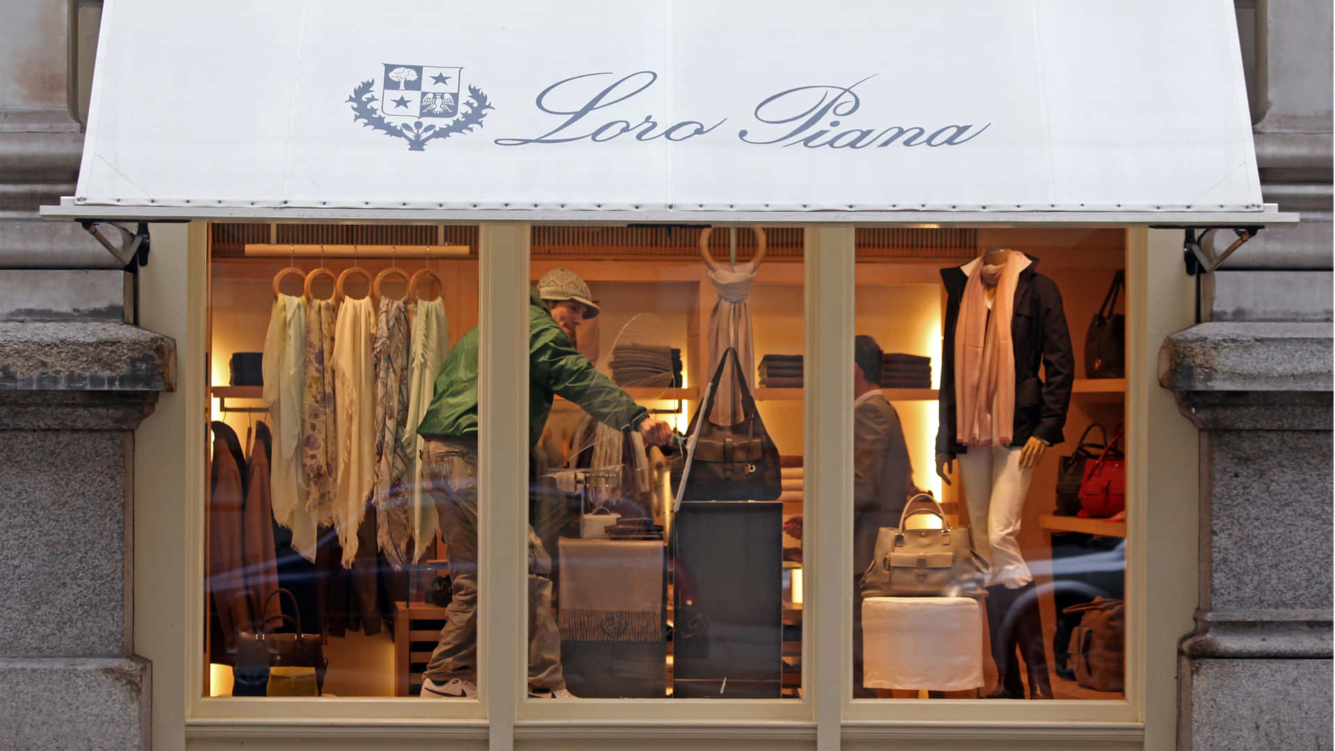 Loro Piana 奢華時裝店櫥窗，店員整理商品和模特兒。