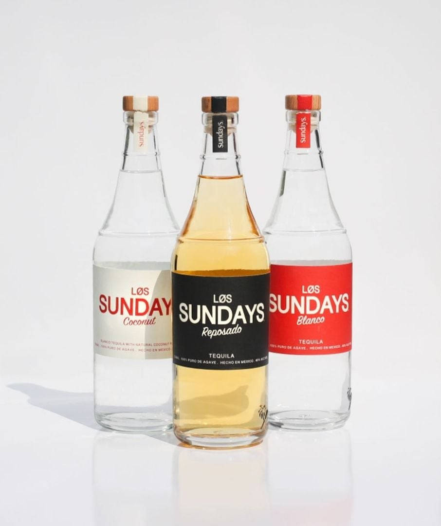 Los Sundays 充滿酒液的玻璃瓶 壁紙 — 三款時尚龍舌蘭酒瓶帶有獨特標籤，在明亮的白色背景前排列成行。