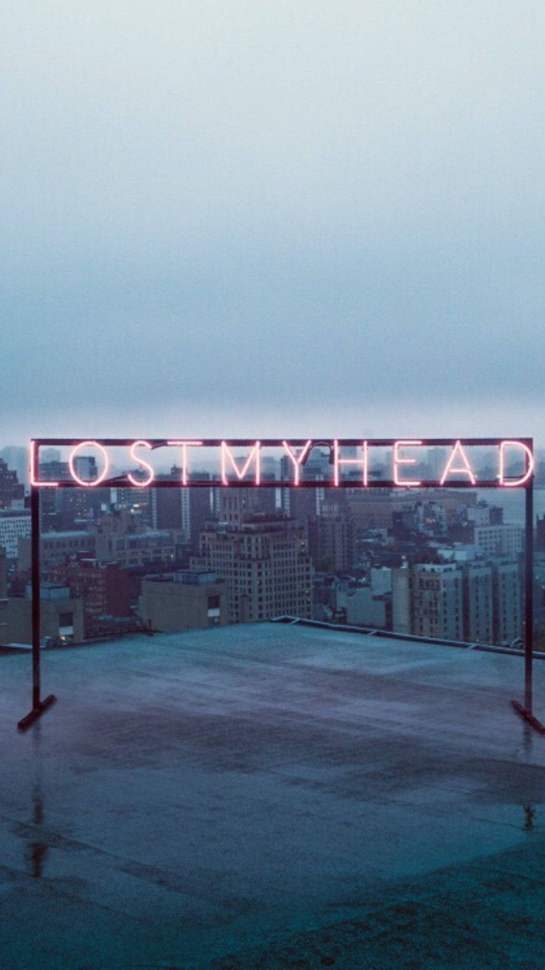 黃昏時分，濕漉漉的城市屋頂上寫著 lost my head 的霓虹燈牌。