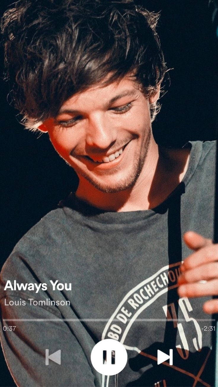 Louis Tomlinson 在音樂表演期間微笑，帶有歌曲疊加層。