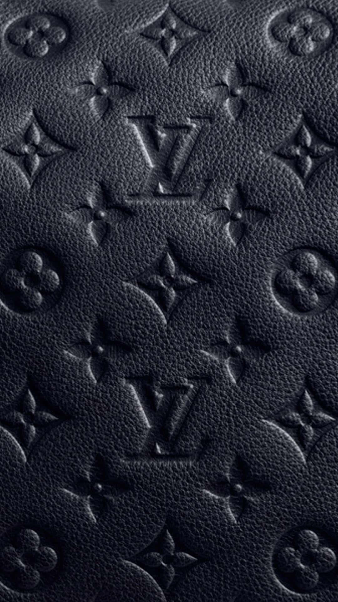 以Louis Vuitton感受時尚與奢華 壁紙 — 黑色紋理皮革的特寫，帶有浮雕路易威登字母組合和花卉圖案，處於深色陰影中。