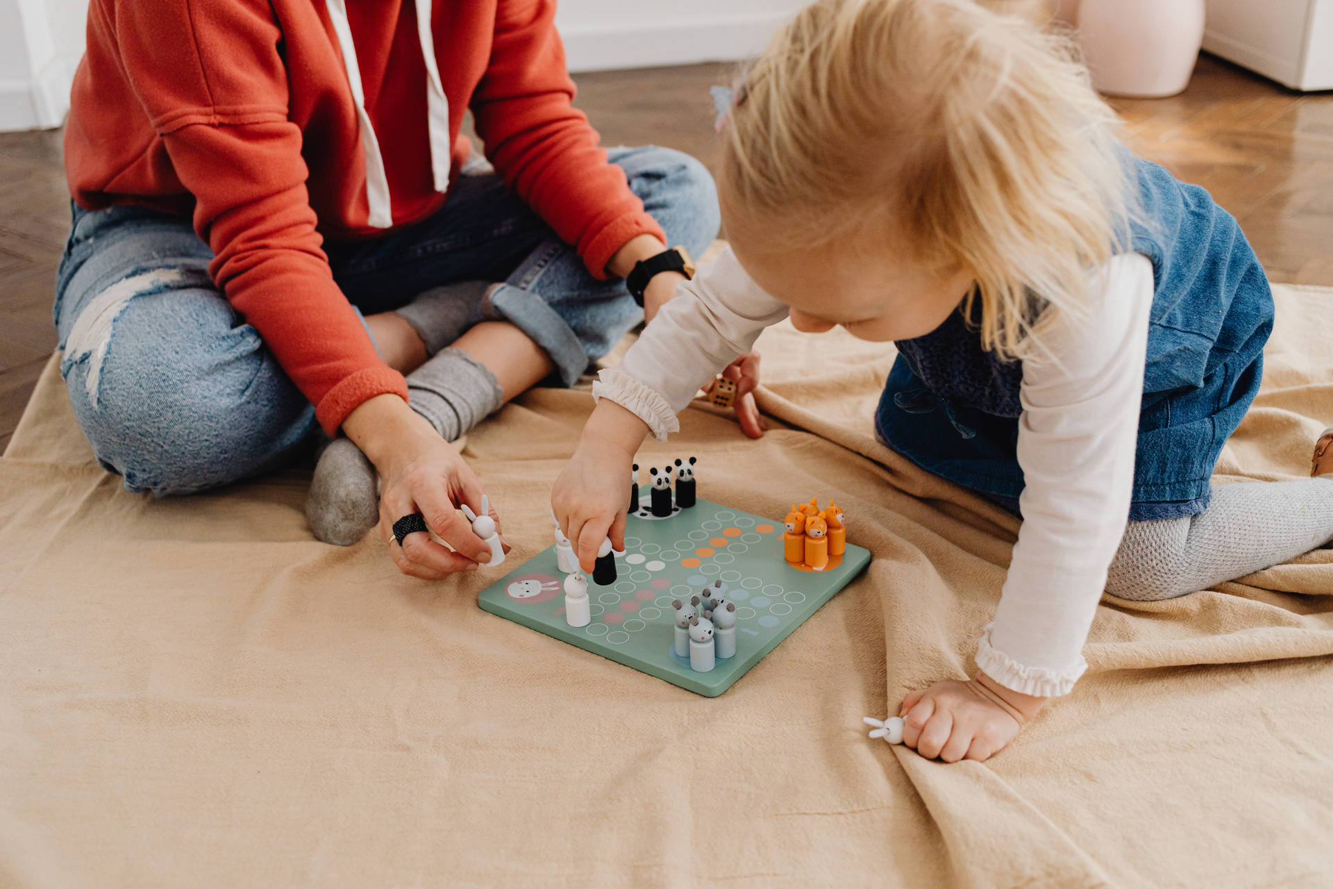 母親和幼兒在地板上玩棋盤遊戲