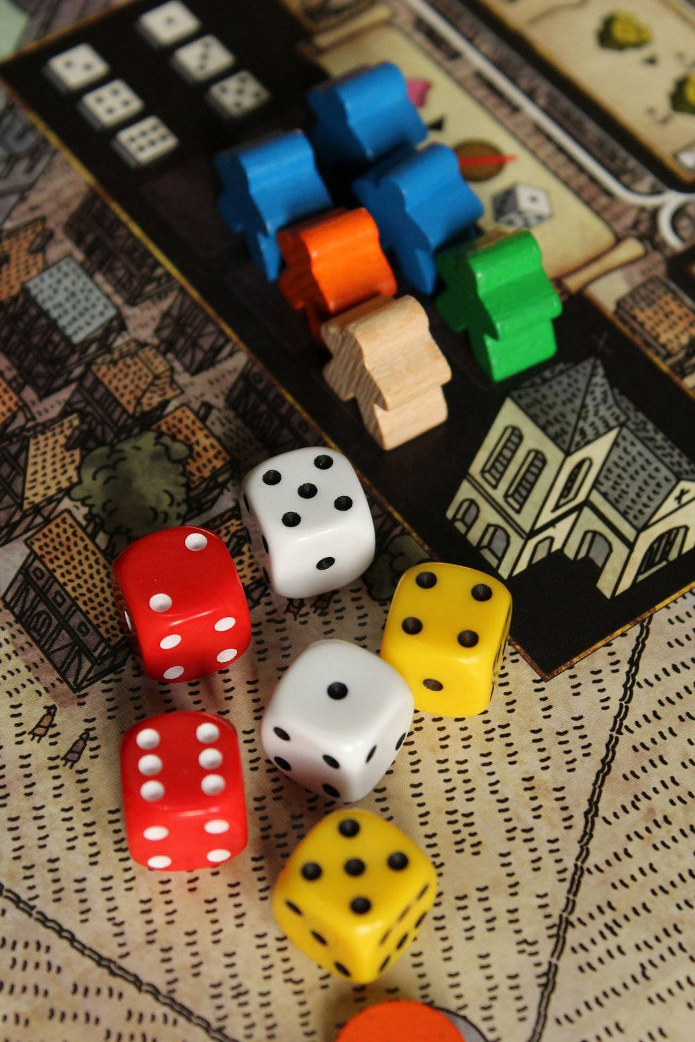 色彩繽紛的骰子和木製遊戲棋子位於細節豐富的棋盤遊戲地圖上。